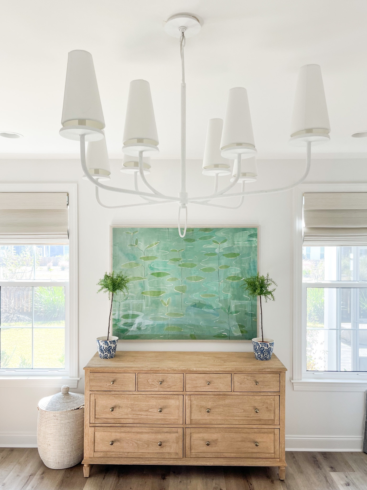 Loving how our primary bedroom is coming together in Florida! We’re using our light wood dresser that we’ve loved for years, but added this new gesso white chandelier, lily pad art, and woven basket hamper. Also linking our white upholstered bed, batik bench, rattan nightstands and blue gray lamps.
.
#ltkhome #ltksalealert #ltkunder100 #ltkunder50 #ltkstyletip #ltkseasonal #ltkfamily coastal master bedroom, green and blue bedroom decor, dresser styling ideas

#LTKunder100 #LTKhome #LTKsalealert