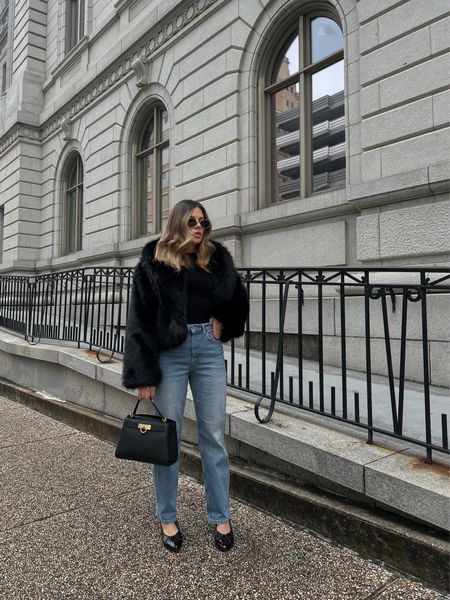 Faux fur black coat styled with denim jeans