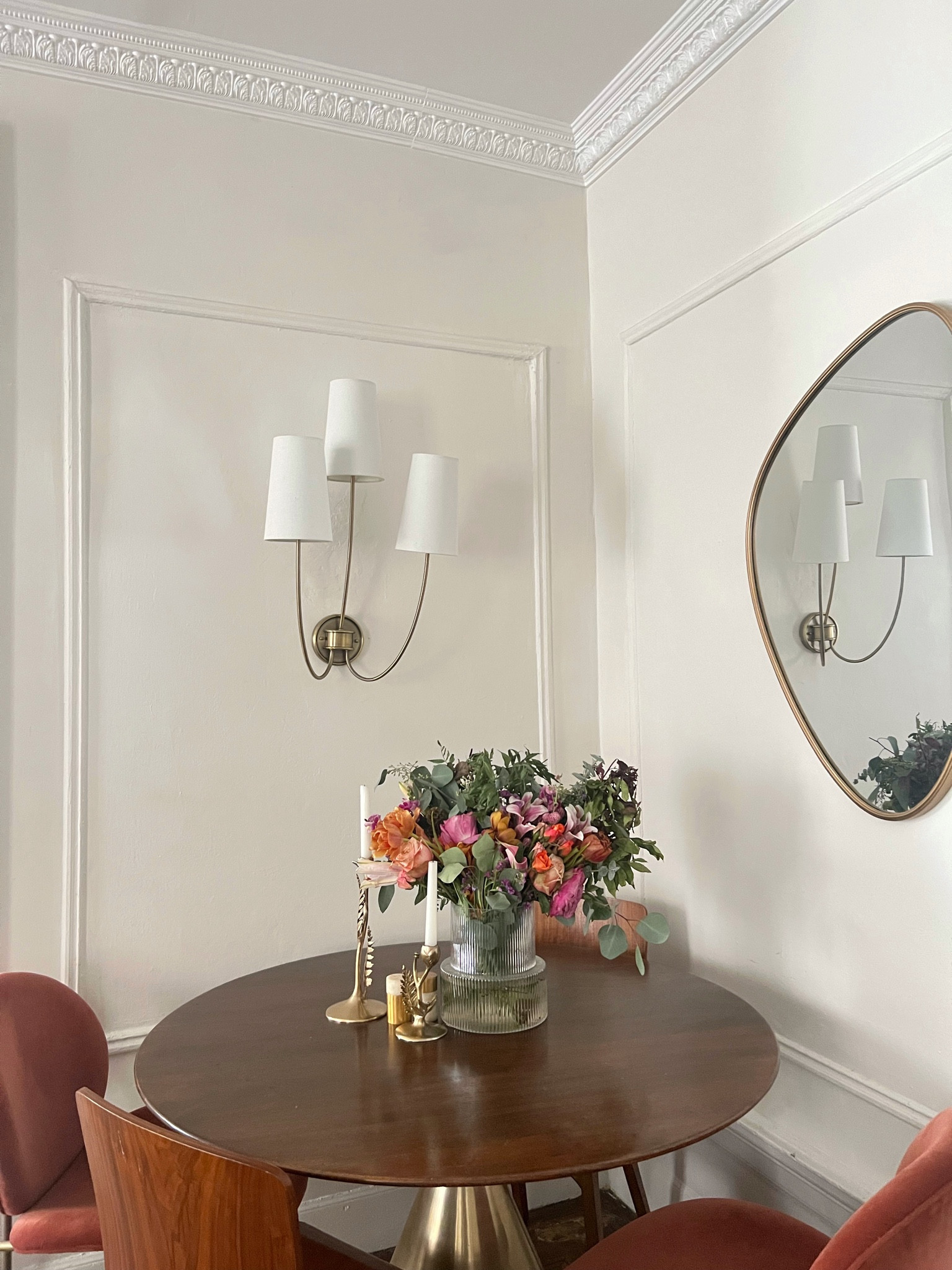 Round dining table, crown molding, wall sconce, velvet dining chair, wood dining chair, assymetrical mirror 

#LTKhome #LTKstyletip