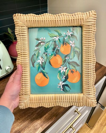Loving this orange blossom art in this scalloped wicker frame so much. I printed the art at home to save money and splurged a bit on the frame 🤣 kitchen art, colorful art, rattan frame, wicker frame, scalloped frame, scalloped frame, scallop decor 

#LTKhome #LTKSeasonal #LTKunder50
