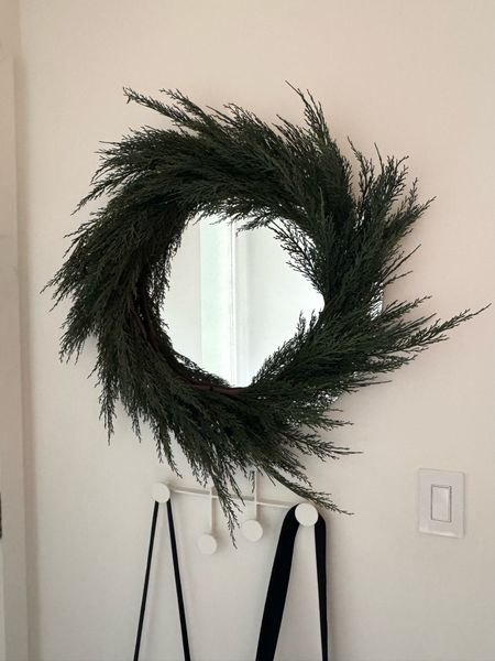 Faux evergreen wreath from Crate and Barrel around the mirror by the front door 

#LTKsalealert #LTKHoliday #LTKhome