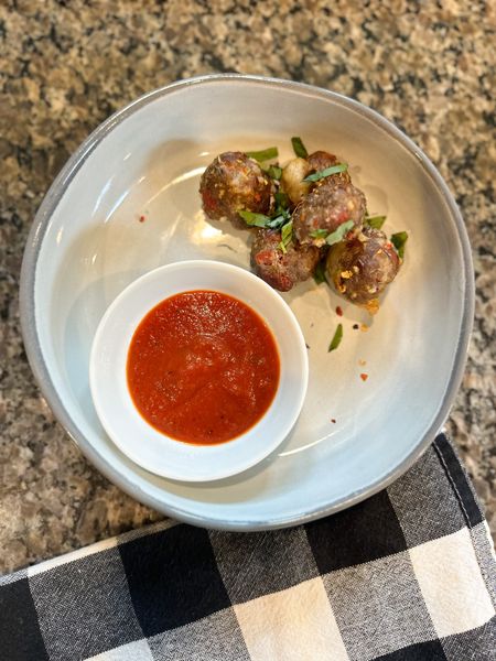 
The whole family is loving these kid-approved pepperoni pizza meatballs!! I slightly adapted the recipe from @fedandfit to make it gluten free. I also doubled the batch and made almost 100 meatballs!!  I’ll freeze half of them for us to eat another week. Here’s the recipe for one batch of meatballs:

Ingredients 
1 pound ground beef
1 pound ground Italian sausage
1 cup diced pepperoni
½ cup parmesan cheese (I used grated but you can also use shredded)
½ cup panko (or bread crumbs)
1 egg
2 tablespoons Italian seasoning
2 teaspoons sea salt
½ teaspoon ground black pepper
3 mozzarella cheese sticks cut into ½-inch pieces
12 ounces pizza sauce warmed, optional
¼ cup fresh basil, optional
Red pepper flakes, optional

Directions 
Add the ground beef, Italian sausage, diced pepperoni, parmesan, panko, egg, Italian seasoning, salt, and pepper to a large bowl and use your hands to mix the ingredients together until fully combined.
Use a scoop to scoop the meatball mixture, and place on a sheet pan (I lined mine with aluminum foil and sprayed it with nonstick cooking spray first)  
Place a ½-inch piece of mozzarella cheese in the center of each meatball and roll the meatball, making sure that the cheese stays in the center.
Bake the meatballs at 400°F for 22-25 minutes,  or until browned.
Serve with warm pizza sauce for dipping, and garnish with red pepper flakes and basil. 

You can also customize these with diced onions, bell pepper, olives, or really any pizza topping!  

Healthy recipe, kids recipe, home finds, dinner 

#LTKfamily #LTKhome