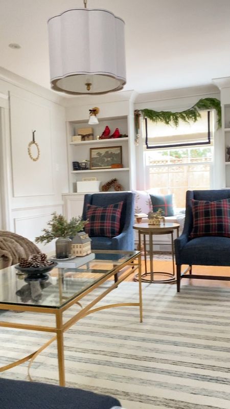 Create a cozy living room with wintry Christmas decor including a Chris Loves Julia x Loloi striped rug, faux fur throw, glass and gold coffee table, velvet sofa, plaid pillow covers, realistic Christmas garland, Christmas pillows in gingham and block print, and decorative accessories. 

#LTKhome #LTKSeasonal #LTKHoliday