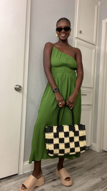 Great summer dress! Green one shoulder dress with smocking at the top worn with tan platform slides, gingham stray tote bag and gold seashell earrings. For beauty I’m wearing clear stick spf, concealer, lipgloss in shade honeysuckle and mascara  

#LTKstyletip #LTKunder100 #LTKtravel