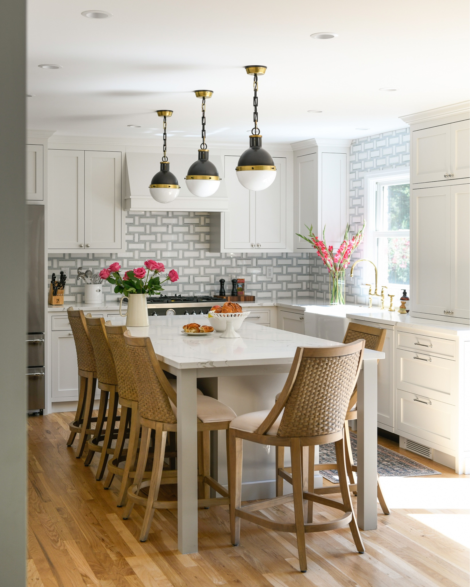 A fresh traditional kitchen with white cabinets, marble basketweave backsplash, apron front sink, brass faucet, vintage range

#LTKFind #LTKhome