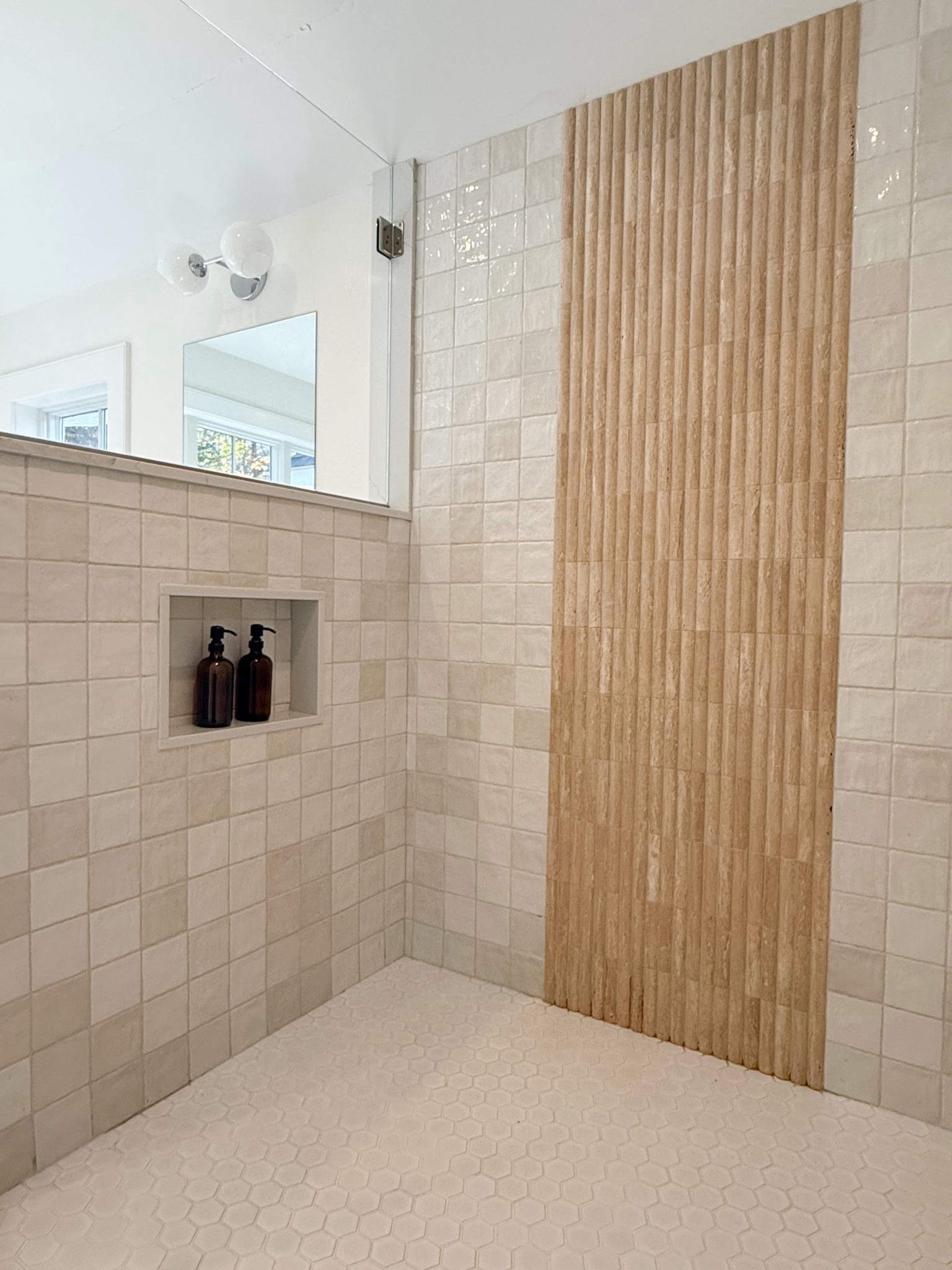 Close-up shot of the bathroom shower, showcasing the stunning rounded accent travertine tile, adding a touch of elegance and texture to the space. 