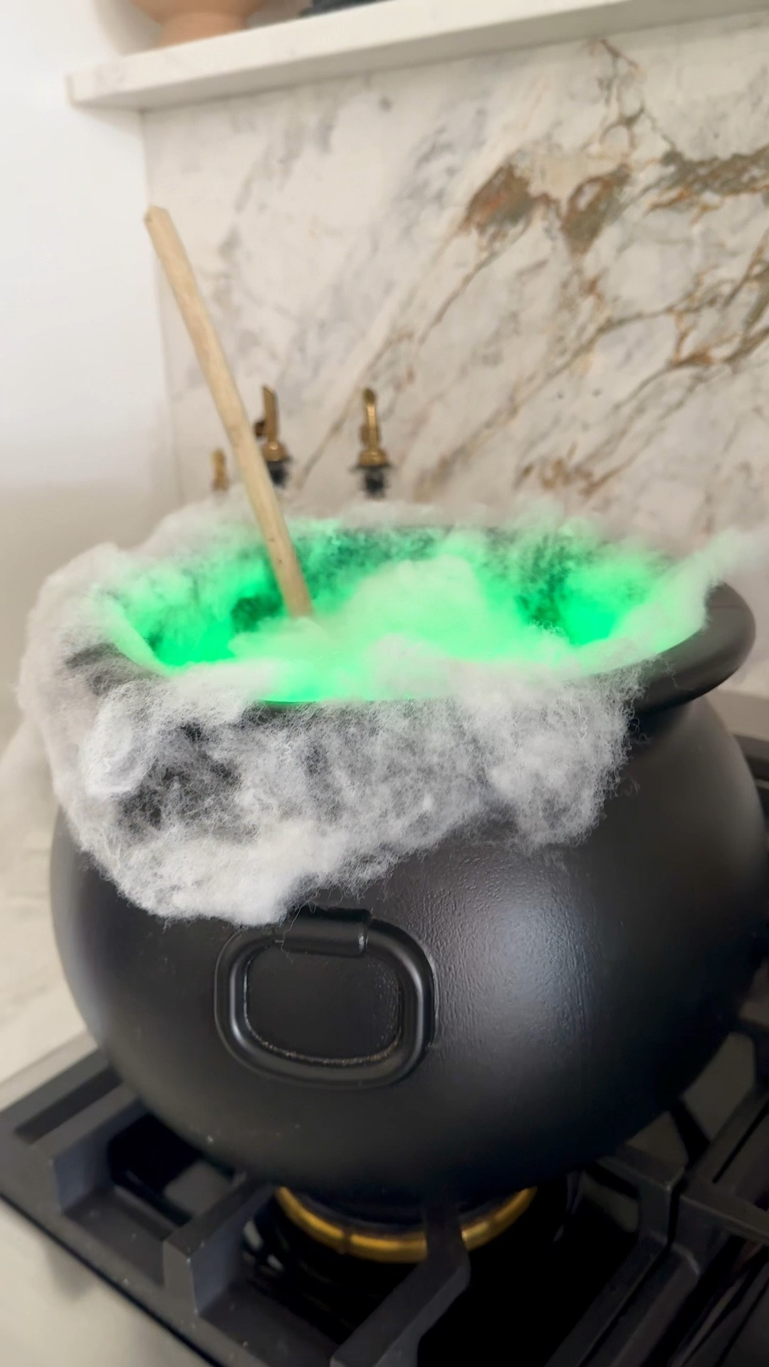 DIY Self-stirring Cauldron, Halloween decoration, witch’s cauldron, magic cauldron #halloween #halloweendecor 

Here's how to make it 👇
1)	Put a paper plate at the bottom of the cauldron to create a flat base.
2)	Place the rotating base onto the plate.
3)	Affix 2-3 LED tea lights to the rotating base with double-sided tape or velcro dots.
4)	Add polyfill around the rim of the cauldron, securing it with the hook half of velcro dots.
5)	Secure a wooden spoon or stick to a plastic cup with Velcro dots or tape and add 3 dots to the bottom of the cup.
6)	Stick the cup to the rotating base.
7)	Add more polyfill to the toptu of the cup.
8)	Turn your husband into a toad and warn the kids not to step on him.
9)	Pour a glass of wine and enjoy the hilarity that ensues! 😂

#LTKSeasonal #LTKVideo #LTKFindsUnder50