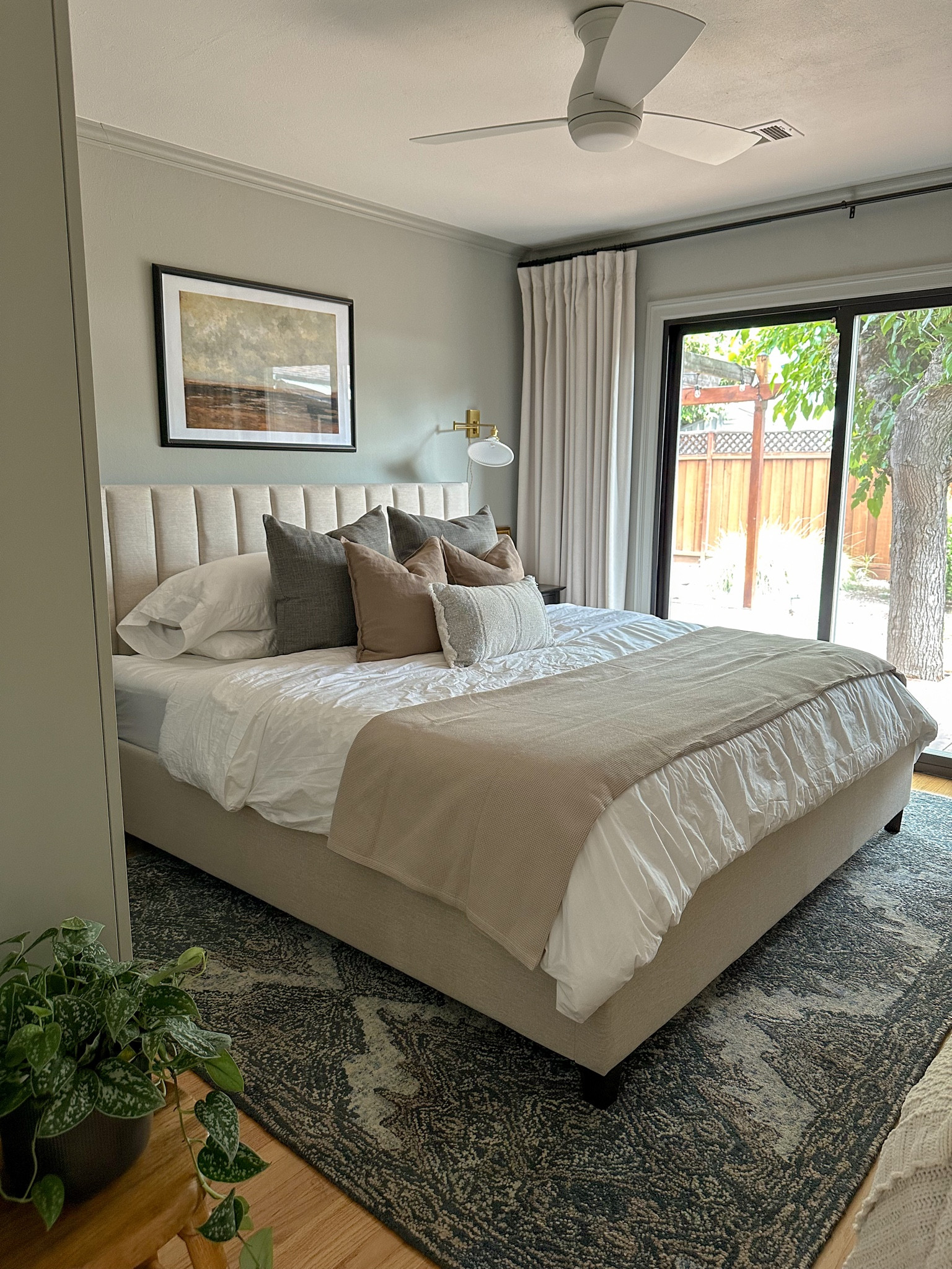 Primary Bedroom makeover; linen pillows; brass sconces; taupe bedding; neutral bedding; soft sheets; linen curtains; white low profile ceiling fan