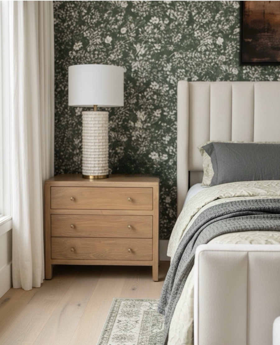 A closer look at this serene modern bedroom reveals a beautifully crafted oak wood nightstand paired with a textured ceramic and brass table lamp. The natural grain of the wood brings warmth against the deep green floral wallpaper, while the neutral linen headboard and layered sage and charcoal bedding add calm sophistication. A perfect blend of texture and tone for an organic modern retreat.

 Shop the look:
Oak wood nightstand | Ceramic brass table lamp | Green floral wallpaper | Upholstered headboard | Sage quilt bedding | Neutral bedroom decor | Cozy modern bedroom | Layered bedding essentials 

#LTKSaleAlert #LTKHome