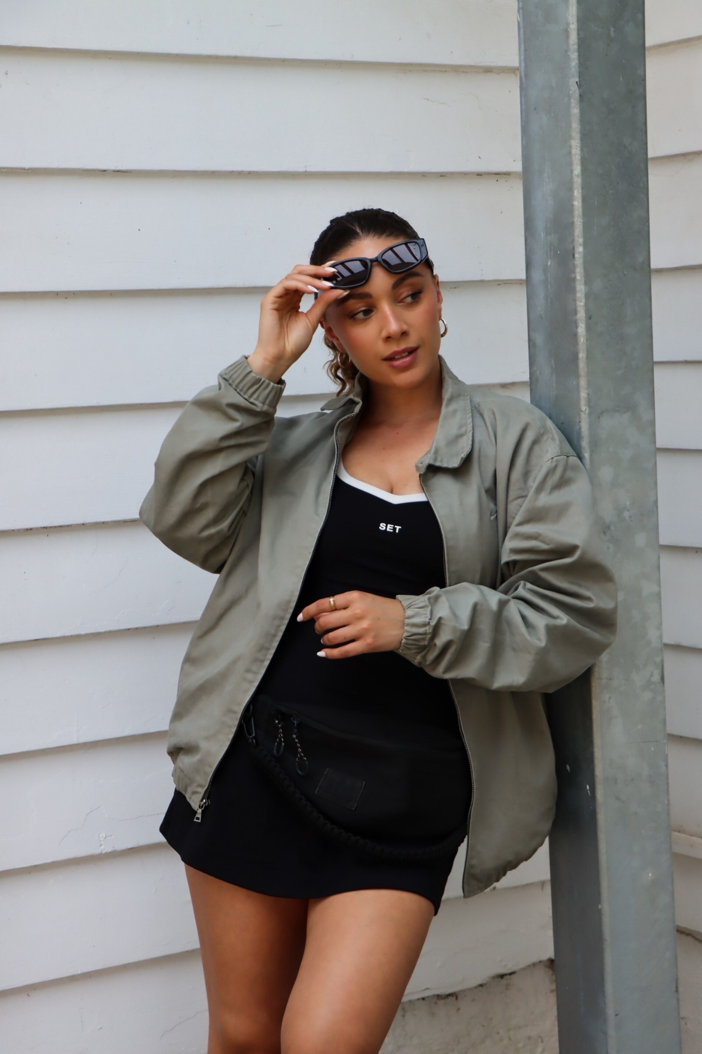 What I wore today! Wearing a lightweight khaki bomber jacket layered over a black athletic dress from SET Active — effortlessly sporty and perfect for transitional weather. Styled with a belt bag, gold hoops, and sleek black sunnies for a minimalist streetwear vibe

	•	Lightweight bomber jacket
	•	Black athletic dress
	•	SET Active outfit
	•	Belt bag outfit
	•	Casual spring outfit
	•	Minimalist street style
	•	Sporty chic look
	•	Athleisure outfit ideas
	•	Everyday neutral outfit
	•	Airport outfit inspo


#LTKSeasonal #LTKSummerEdit #LTKStyleTip