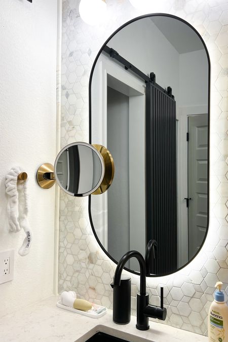 Our oval led backlit mirrors make our bathroom feel like an upscale, luxury hotel! We paired them with a light up, magnifying mirror, automatic soap dispenser, and modern black sink for a super modern look.

#LTKFind #LTKhome #LTKunder100