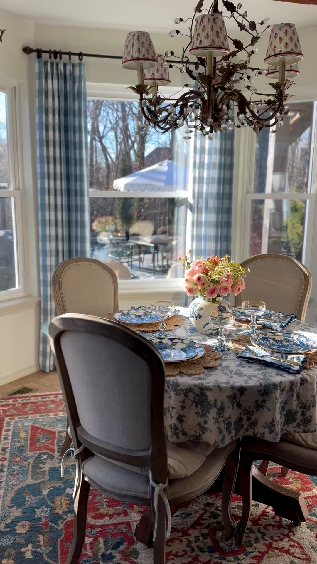 Custom pinch pleat buffalo check curtains, blue floral tablecloth, blue floral plates, Royal Check enamel plates, blue floral ceramic vase, rug, crystal chandelier, pleated chandelier lampshades, upholstered curved dining chairs, glassware, coupe glasswaree

#LTKHome #LTKSaleAlert #LTKSeasonal