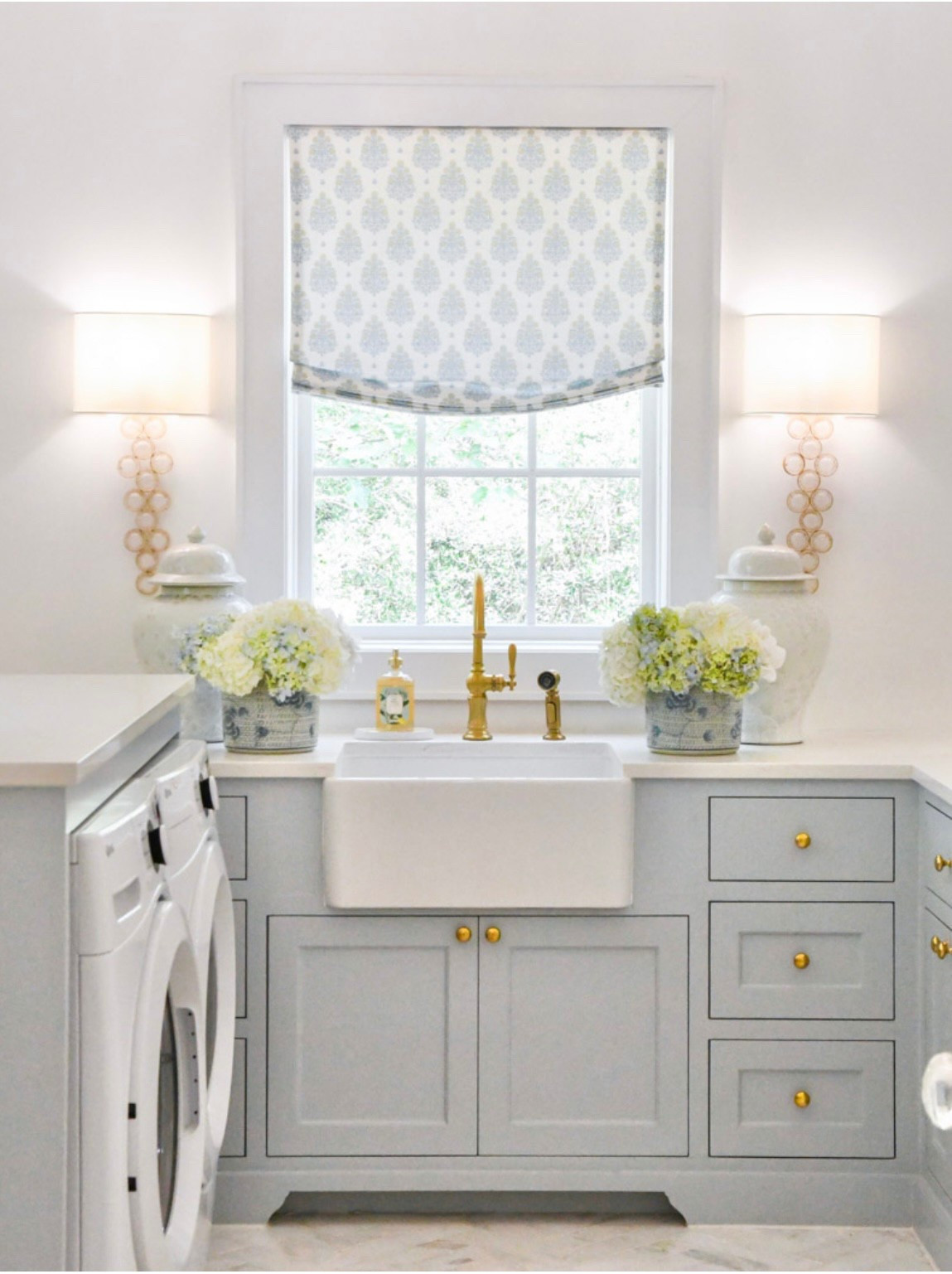 Utility room home decor
Beautiful soft blue utility room with gold wall sconces, white front load washer and dryer, and gold faucet 

#LTKHome