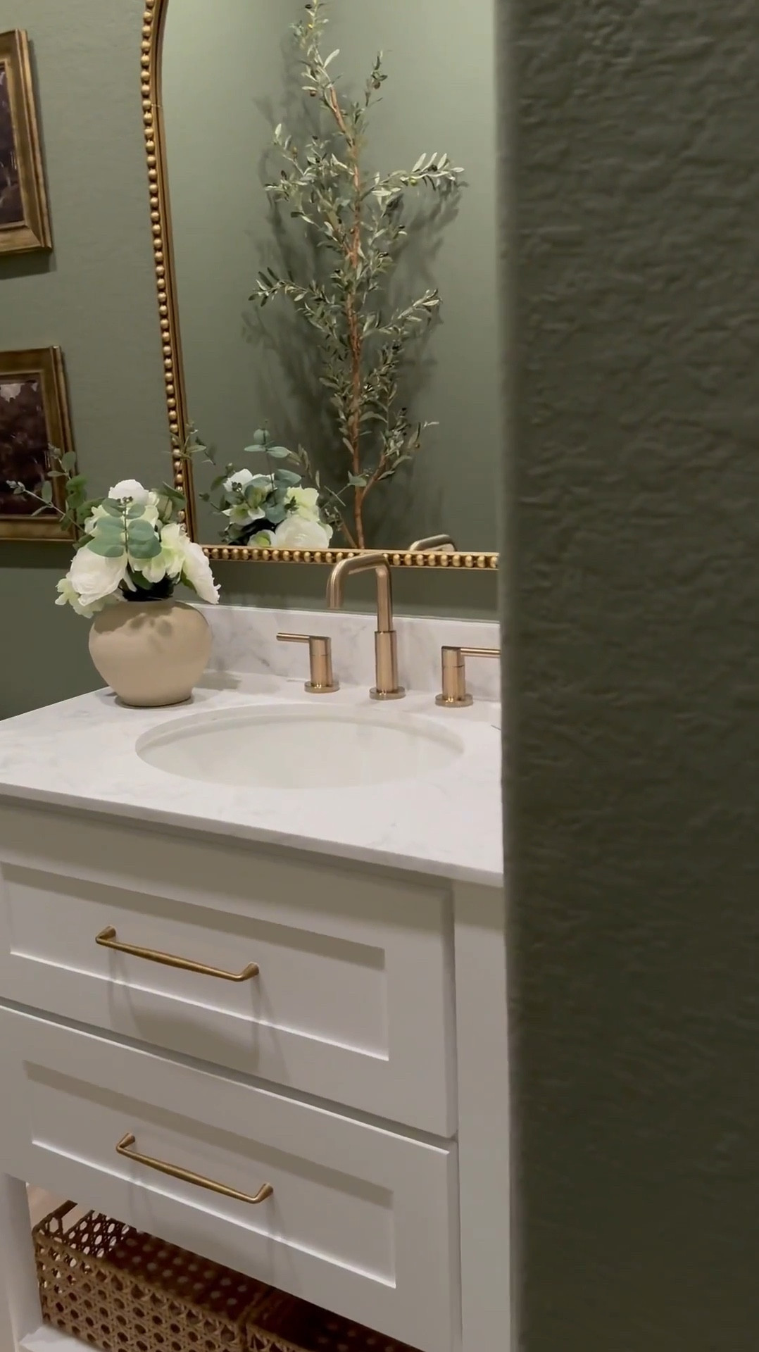 If you’re considering color drenching a room green, I’m telling you, THIS might be the perfect color for you … go for it! 🤍

Walls & Ceiling - flat finish
Baseboards - satin finish

I was apprehensive but I decided to paint the ceiling 😬 …. Surprisingly it made the room feel larger! 

I chose brass finishes to create a vintage feel…, modern vintage perhaps …??? 😆.. 

The mirror is 30x40 inches… 

I added a new light fixture and it now faces upward … which makes that wall feel taller!

I wasn’t in love with this builder grade vanity tbh😆, matter-fact, I wanted to change it… it wasn’t functional …but now i wanna keep it lol 😂… I added brass hardware, cute baskets, led light strips on the bottom and now it’s a whole new unit….. you can even add battery powered/rechargeable/plug in led light strips .. whatever fits your lifestyle 

Ok let’s talk about this stunning planter!!! …. We all love an olive tree don’t we? 😆 … and I wanted something tall and slim… this planter was… perfect plus it added to the moody feeling of the room 🥰

#bathroommakeover #powderroom #powderroomdesign #homedecorideas #beforeafter

#LTKSaleAlert #LTKStyleTip #LTKHome