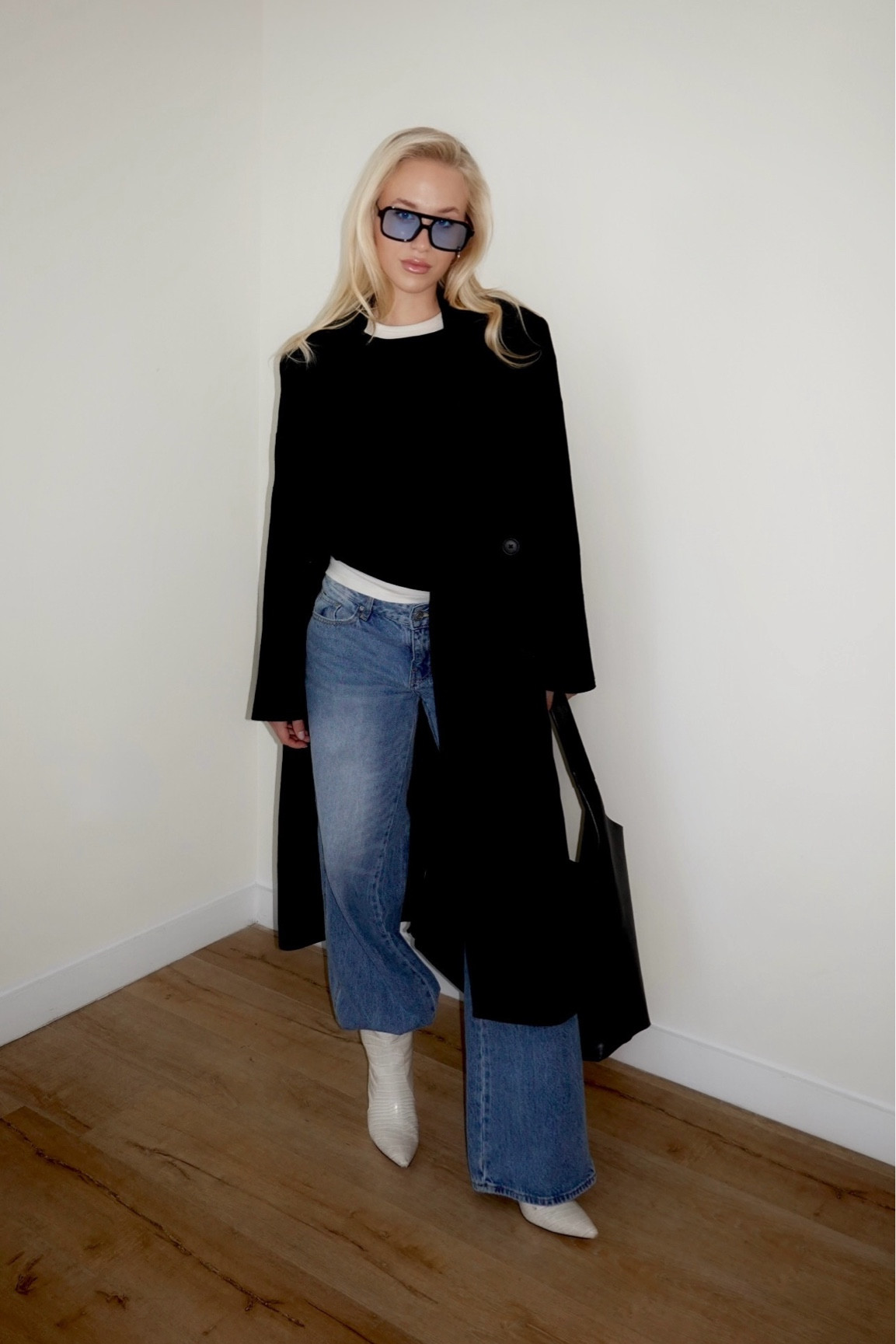 Effortlessly chic: Pairing a tailored black coat with timeless denim, bold sunglasses, and sleek white boots for a Scandi-inspired minimalist look. 

#LTKU #LTKStyleTip