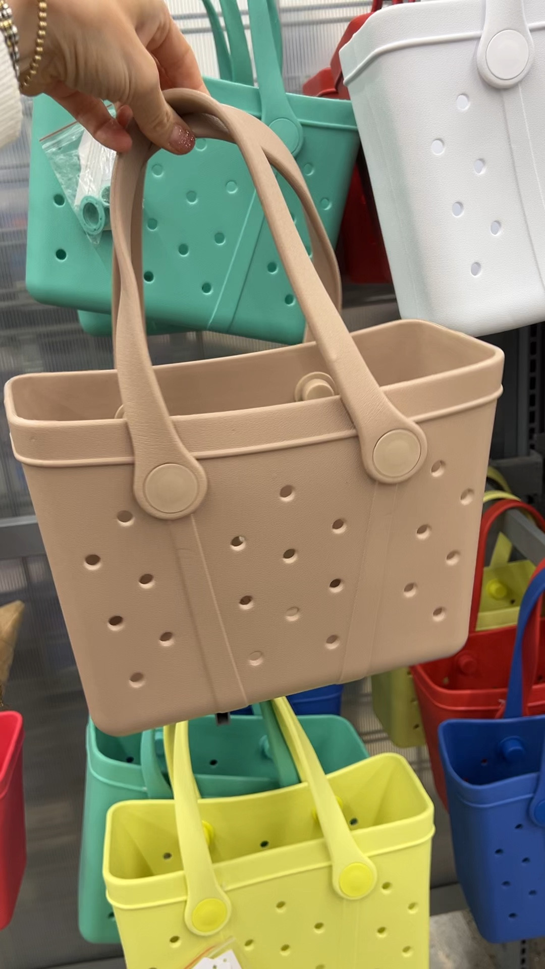 Bogg bag look for less at Walmart! I got one last year and love it. One of the little caps that keeps the strap on fell off and I lost it (you can twist them back on) but otherwise a great bag and I’d buy another for the price. 