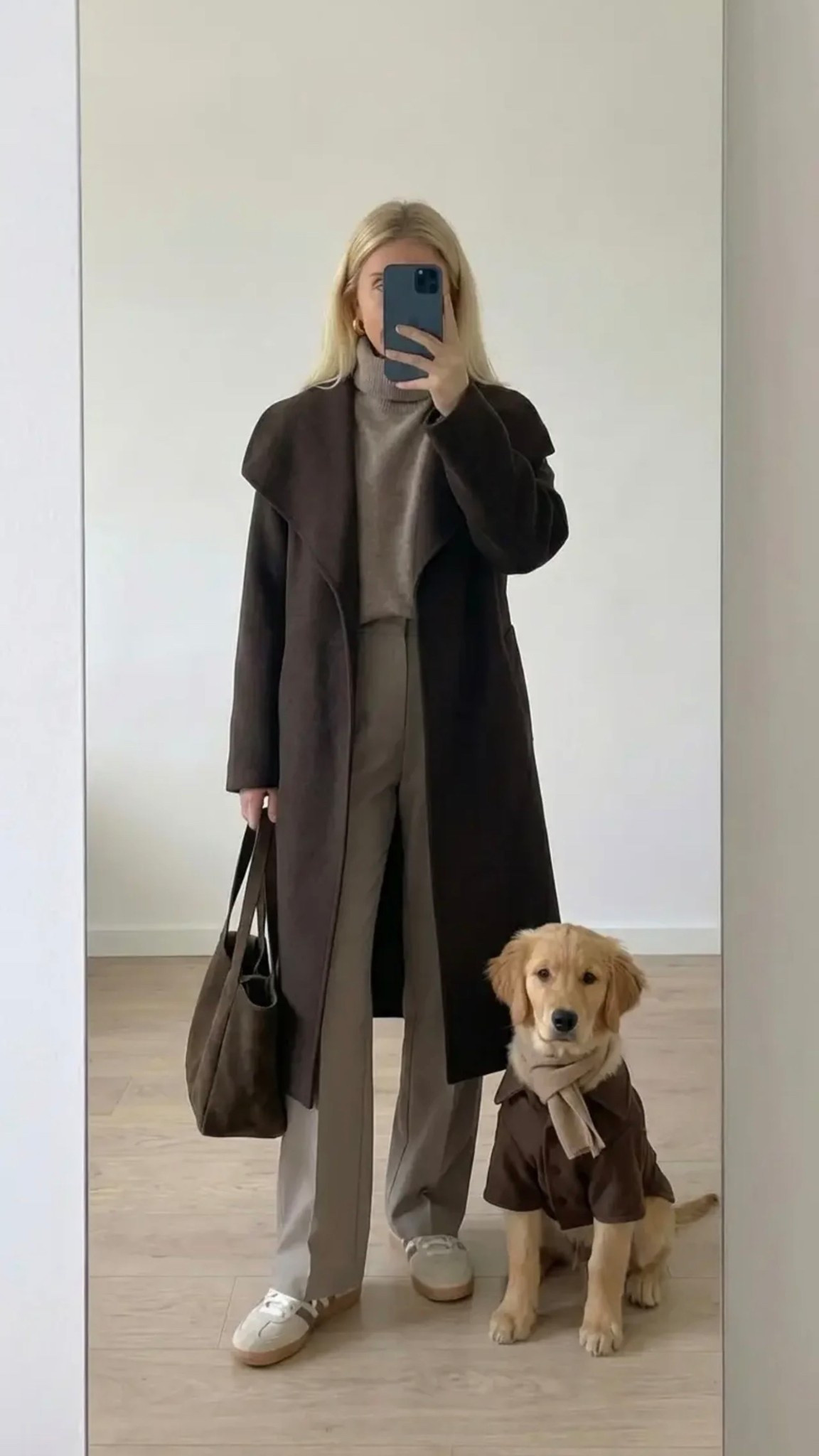Minimalist mirror selfie of a chic woman in a neutral capsule wardrobe outfit: long dark brown tailored coat, beige ribbed turtleneck sweater, light-wash straight jeans, brown suede loafers, structured leather tote. Golden retriever puppy wearing matching coat and knit sweater beside her. Clean Scandinavian apartment, soft natural light, calm aesthetic, quiet luxury vibe, neutral palette, modern lifestyle fashion photography, vertical composition.

30 words (with /):
Tailored/long/brown/coat / soft/beige/turtleneck / light/wash/straight/jeans / suede/brown/loafers / structured/leather/tote / cozy/minimalist/neutral/aesthetic / golden/retriever/style/match / quiet/luxury/everyday/chic / effortless/fall/classic

Hashtags:
#quietluxury #capsulewardrobe #minimalstyle #neutralaesthetic #classicstyle #effortlesschic #falloutfit #cozyfashion #streetstyleminimal #timelessstyle #everydayelegance #modernminimal #styleinspo #ootdstyle #fashioninspo #minimalfashion #cleanstyle #scandinavianstyle #neutraltones #dogmomstyle #goldenretrieverlove #elevatedcasual #quietluxurylook #simplechic #capsulestyle

#LTKFestival #LTKSpringSale #LTKdayinmylife
