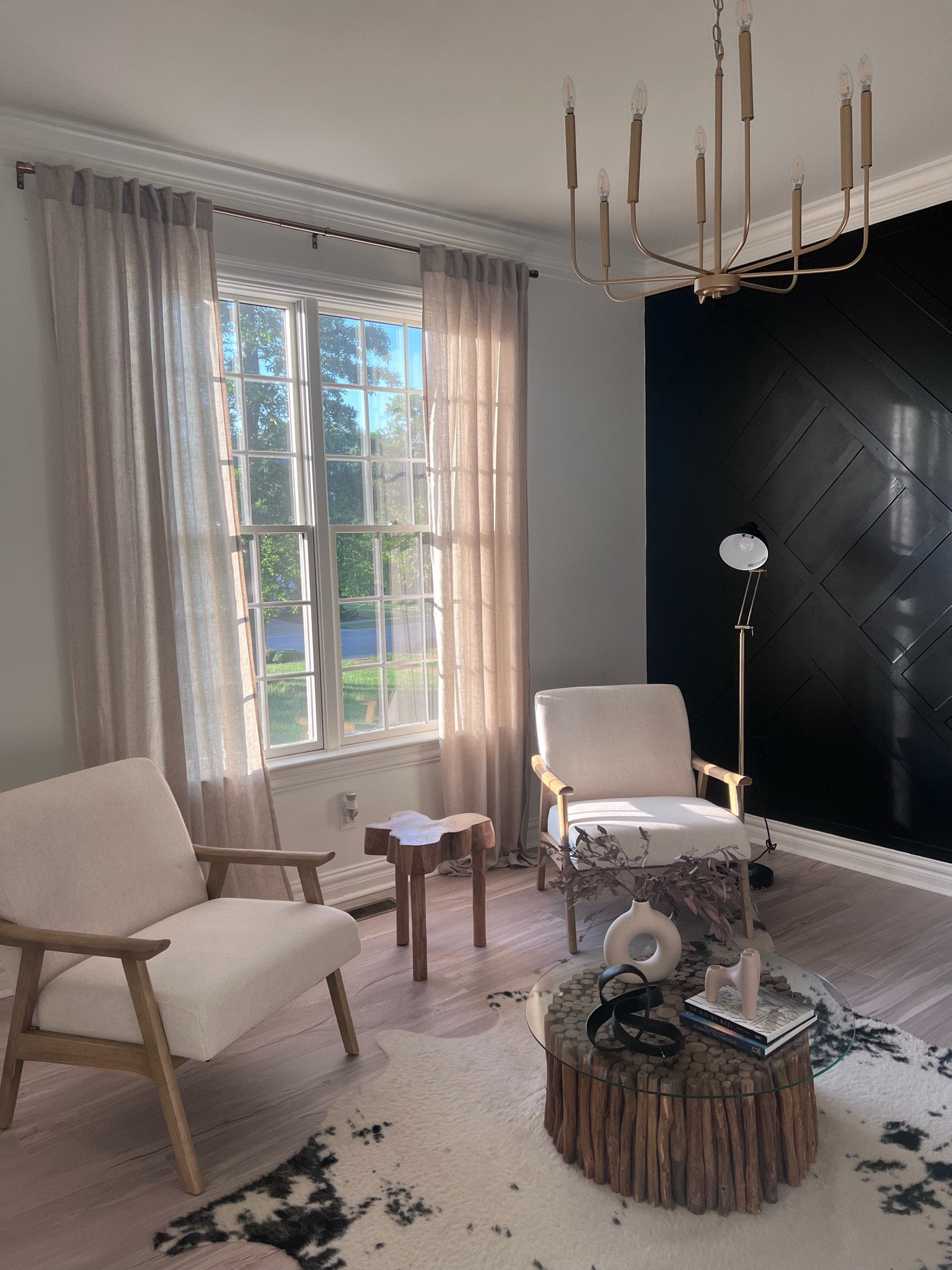 Modern sitting area in with light wood accent chairs, linen curtains and linens details as well as wood and black decor. Gold chandelier. Warm modern or organic modern mm style. Added variables for anything that’s sold out. Rug and chairs on sale! 

#LTKhome #LTKFind #LTKsalealert