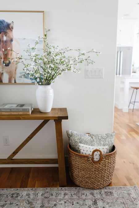 In my entryway, I have a wood console table with a white Amazon vase filled with faux stems on top. Next to the table I have a pretty basket filled with throw pillows  

#LTKhome #LTKsalealert #LTKFind