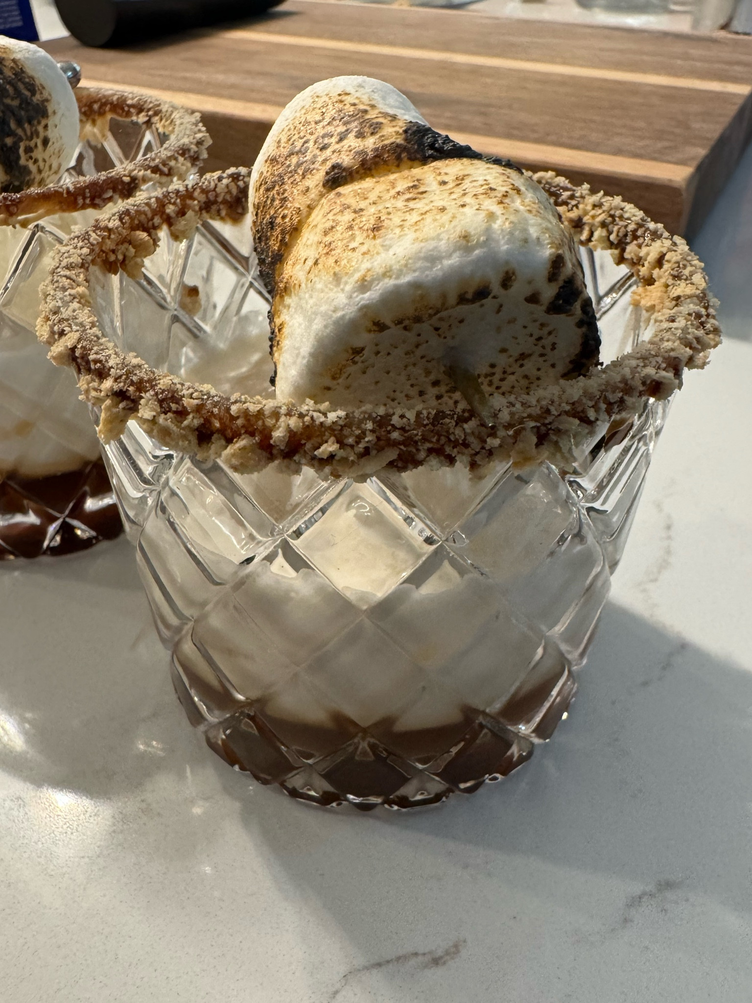 It’s almost time for S’mores - this is the perfect adult s’mores!  Dip the rim in melted chocolate and then in graham cracker crumbs and place ice in glass. Mix 1 ounce chocolate liqueur and 1/2 ounce vanilla vodka or white rum in shaker with ice.  Shake until outside is cold and, using a strainer, pour into prepared glass.  Top with 1.5 ounces of heavy cream.  Place marshmallows on pick and heat with torch.  Place pick across top of glass!

#LTKParties #LTKFallSale #LTKSeasonal