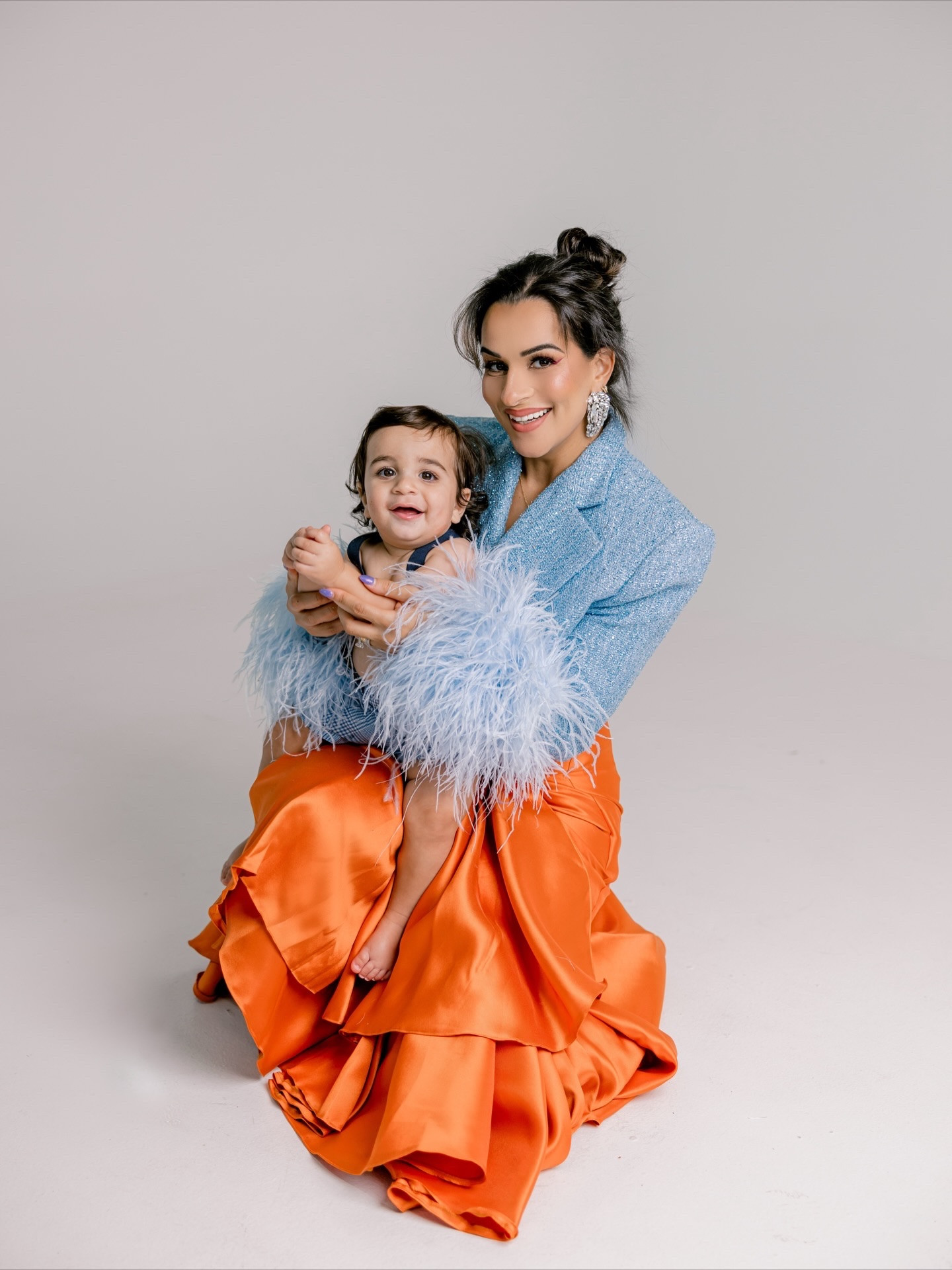 Wearing the Becca High Waist Wrap Midi Skirt by @imadeduso_ !!!!! ICONIC. 
So unique / so different / so full of color & personality.
A brand that genuinely has a special place in my heart. A brand that is true ART through every single piece. 🤯🧡

📸: @santinamitaj_photography
🎈: @bubble_decors 
🎂: @fortheloveofflour_nj 
💄: @nancysmakeupartistry 
Blazer: @bronxandbanco 
Gown: @delficollective
Earrings: @area & @davidkomalondon

feather blazer, statement outfit, mom style, holiday photos, colorful fashion, family shoot, dressy looks, baby boy, toddler outfit, LTK moms, fashion, style, stylish mom, birthday photo shoot 

#LTKHoliday #LTKSeasonal #LTKGiftGuide