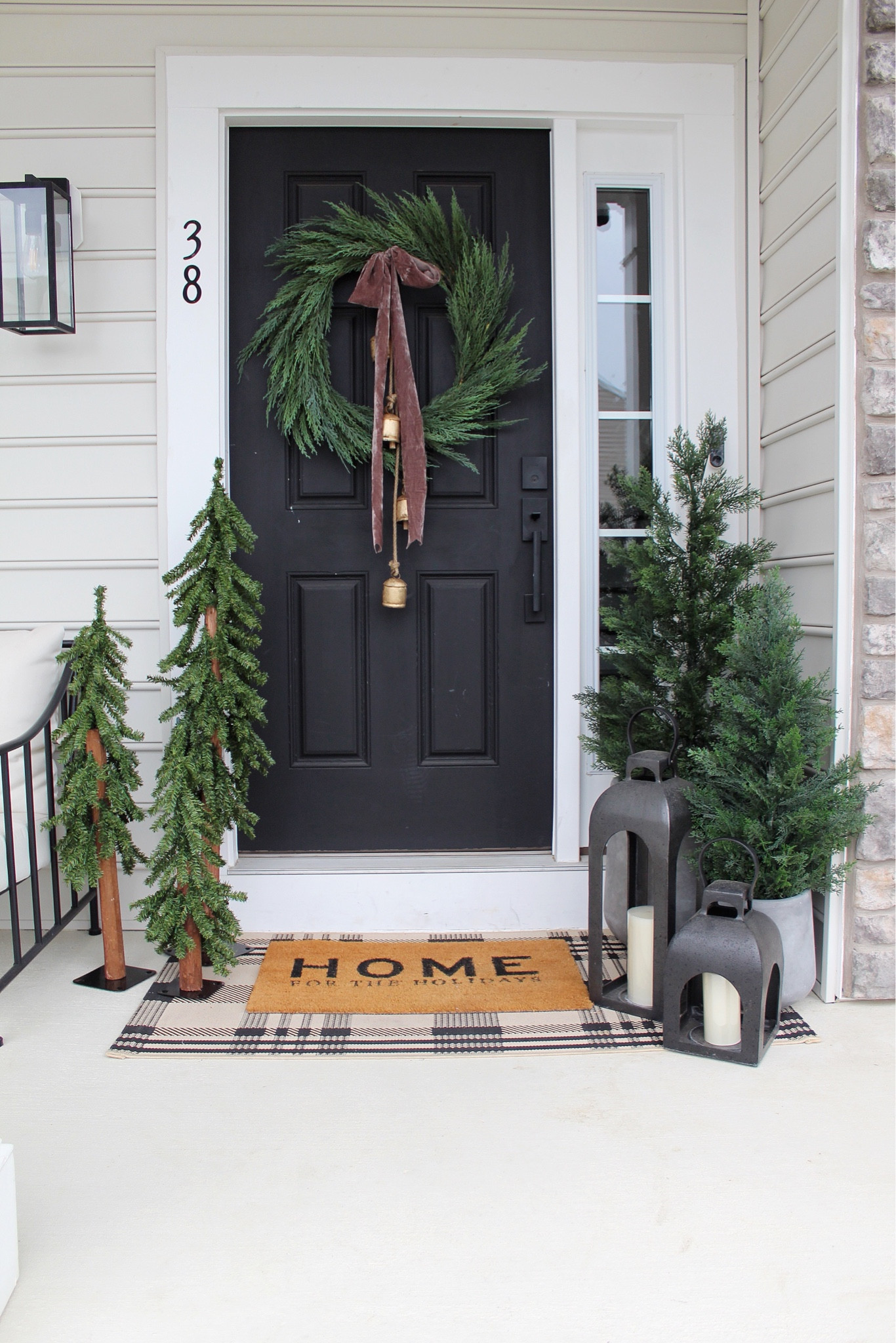 Holiday front porch, doormat, rug, wreath, ribbon, bells, lantern, trees 

#LTKHoliday #LTKSeasonal #LTKHome