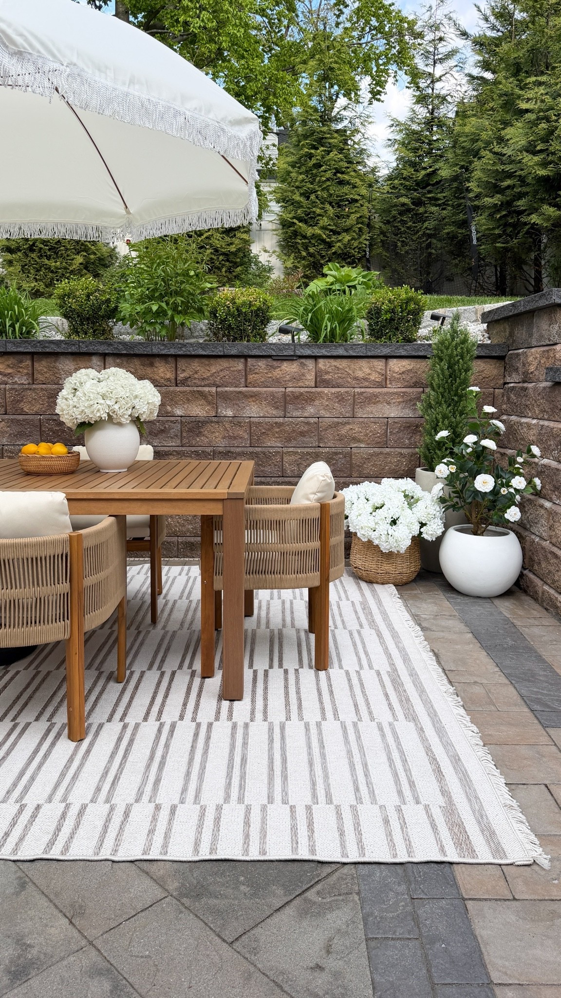 #ad This rug & woven cable chairs completely grounded this entire outdoor space.  🌿🤎

I always say layering is what makes a home feel warm and intentional, and adding this striped outdoor rug completely transformed the patio. It softened all the stone textures and tied together the furniture and florals so beautifully. 

Linked all my outdoor favorites here ✨

#Wayfair #WayfairPartner #Outdoor #Wishyouwerehere #OutdoorLiving #PatioInspo #ModernOrganic #OutdoorStyling #BackyardInspo #DesignerLookForLess