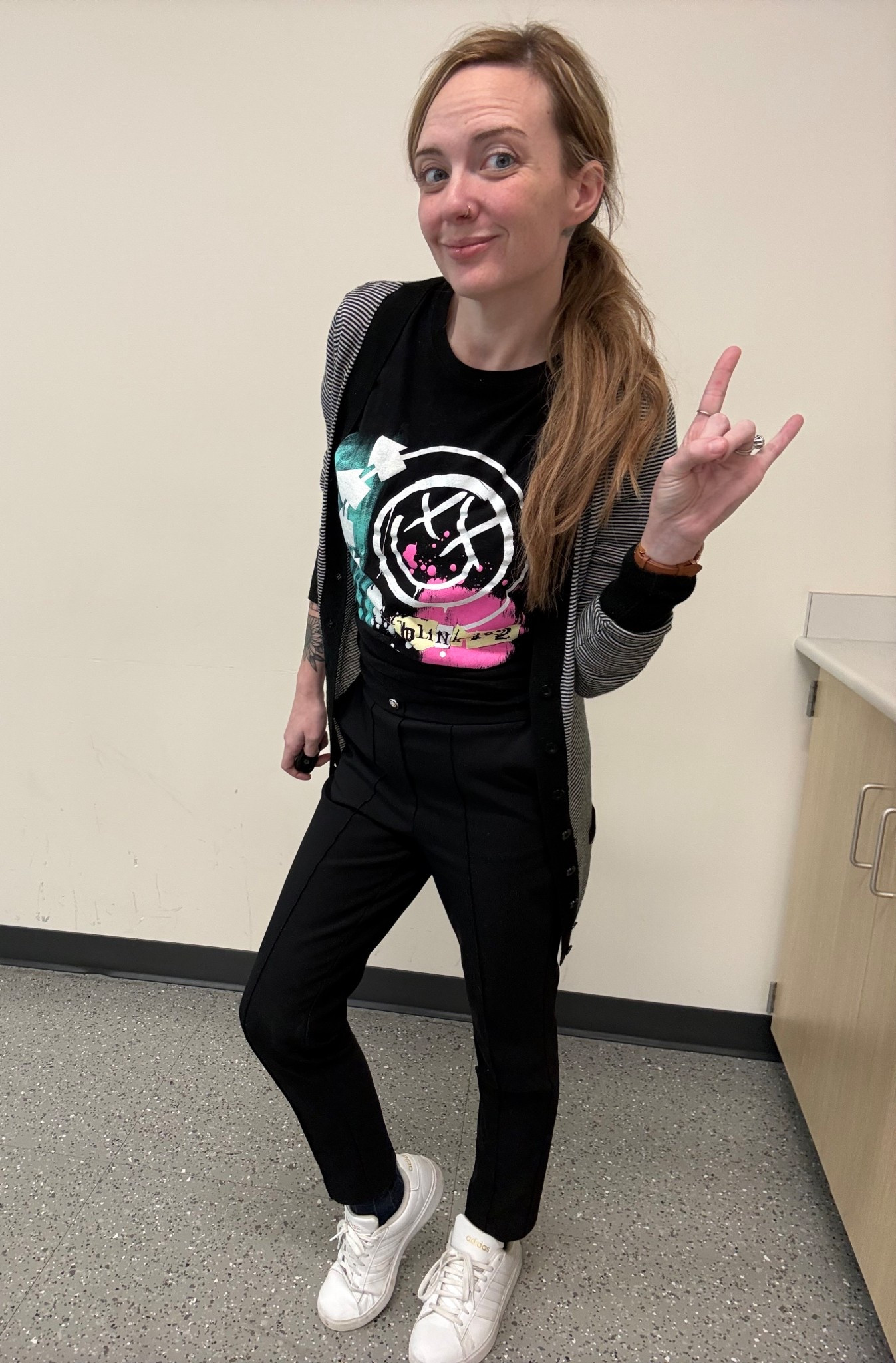 Graphic band tee outfit for everyday wear. Blink 182 shirt styled with black straight leg pants and white sneakers. Casual teacher outfit idea that works for school, errands, or weekend style. Layered with a lightweight cardigan for extra comfort. Black pants are slim fit. White sneakers are classic and easy to pair with any outfit. Simple, comfy, and polished casual look.

Serving teacher energy but make it pop punk lore.

#LTKootd #LTKmomlife #LTKdayinmylife