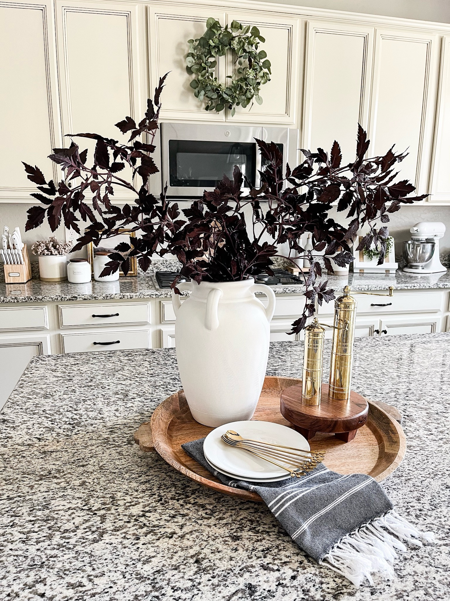 Early fall late summer kitchen counter styling!
This is a great transition when you are still holding on to summer but want to start warming things up for fall!
I used 2 of the cimicifuga stems for reference and I also linked a cheaper version as well. 

Round wood tray | round footed wood serving stand | gold leaf spoons | kitchen towel | vase | plum cimicifuga stems | faux fall stems 

#LTKStyleTip #LTKSeasonal #LTKHome