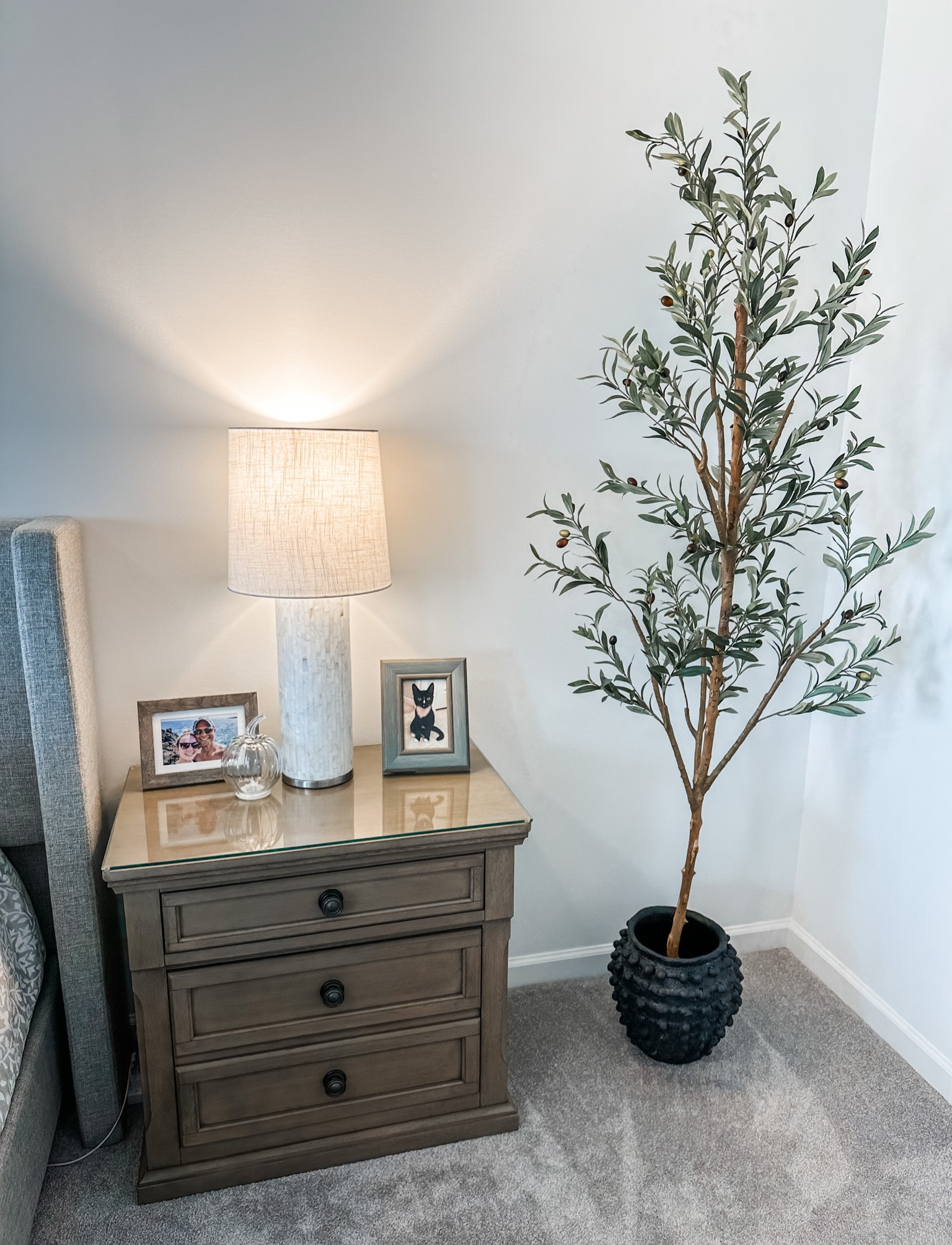 Neutral bedroom decor / cozy bedroom / faux olive tree / Anthropologie Minka pot / black ceramic pot / capiz shell lamp / neutral nightstand / upholstered bed / sleek socket 

#LTKhome #LTKsalealert #LTKstyletip