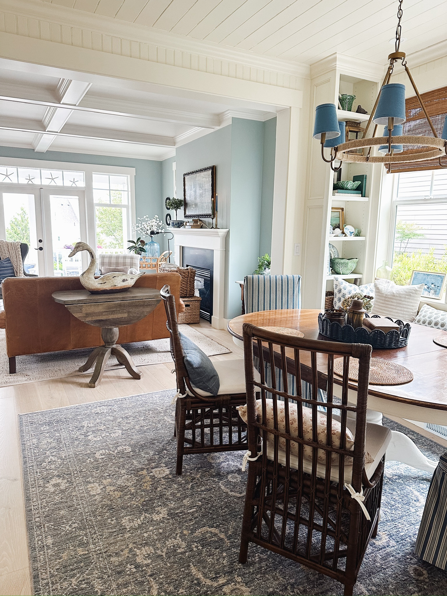 Dining and living room decor - Navy blue rug, similar bamboo dining chairs, jute wrapped brass chandelier with blue shades (periwinkle color), woven chargers, leather chair, plaid armchair, cabbage bowl 

#LTKHome #LTKStyleTip #LTKSeasonal
