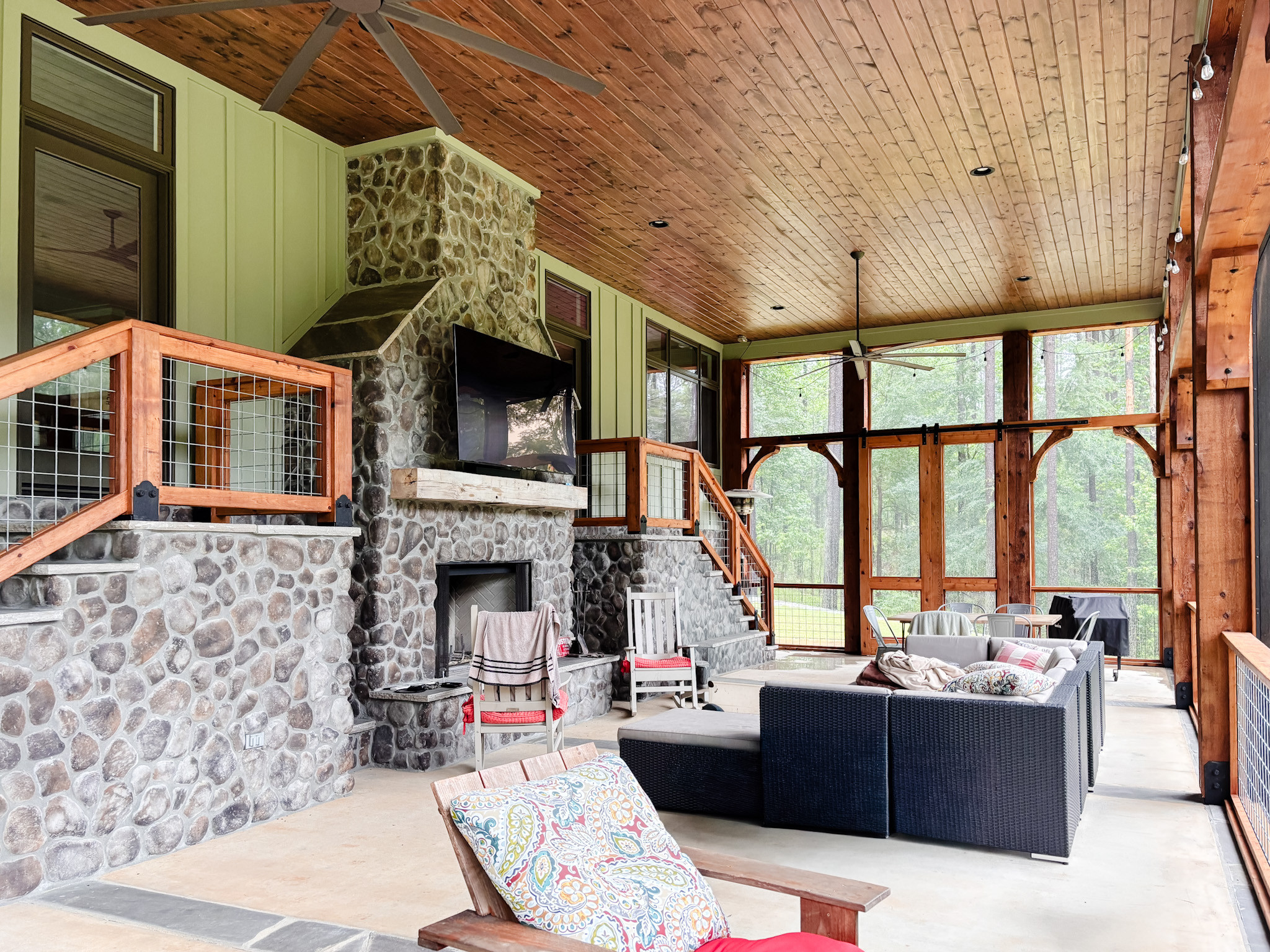An outdoor room that lives like the indoors. 🌿 The screened porch is thoughtfully designed as an extension of the home, with oversized sliding screen doors that open to the yard and invite the outdoors in. A grand fireplace with a deep sitting hearth anchors the space, layered with cozy seating and a sleek black stone grill for effortless entertaining. It’s the kind of setup made for slow evenings, shared meals, and gathering well past sunset.

Shop a similar look to create an outdoor space meant for year-round living.
#LTKHome #OutdoorLiving #ScreenedPorch #ShopTheLook #EntertainingSpaces #TimelessDesign 

 #LTKHome