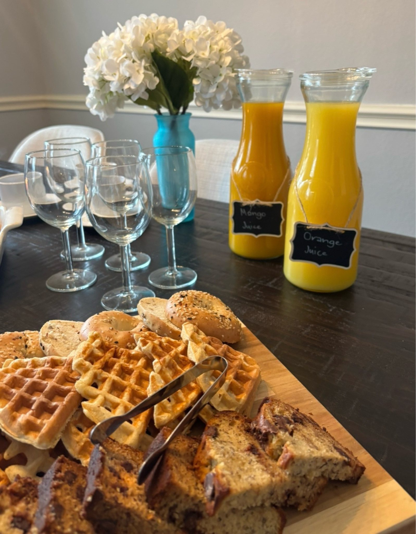 Brunch tablescape 
#brunch #woodcheeseboard #carafe #juicecarafe #glasses #wineglass #servingtongs #bluevase #fauxfllowers 

#LTKHome #LTKParties #LTKFindsUnder50