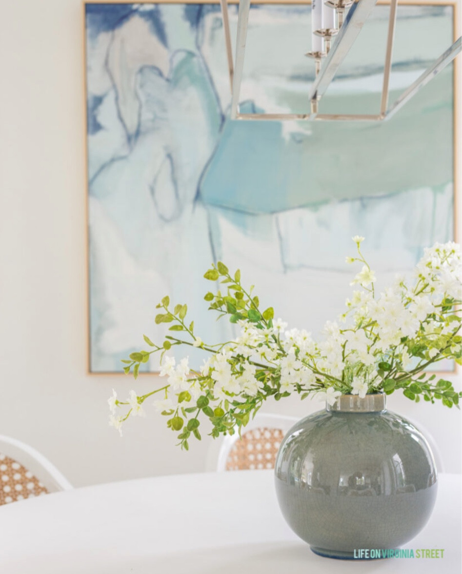 I love how open and airy our dining room is! I’ve styled our round white dining room table with cane dining chairs, a gorgeous glass vase and faux greenery! I added a linear chandelier and fun abstract art to the room as well! Linked other items in our dining room including a distressed wood buffet. 

dining room, blue and white decor, neutral decor, pb inspired dining room, dining room table, dining room chairs, dining room rug, dining room buffet

#LTKsalealert #LTKunder100

#LTKfamily #LTKhome #LTKstyletip