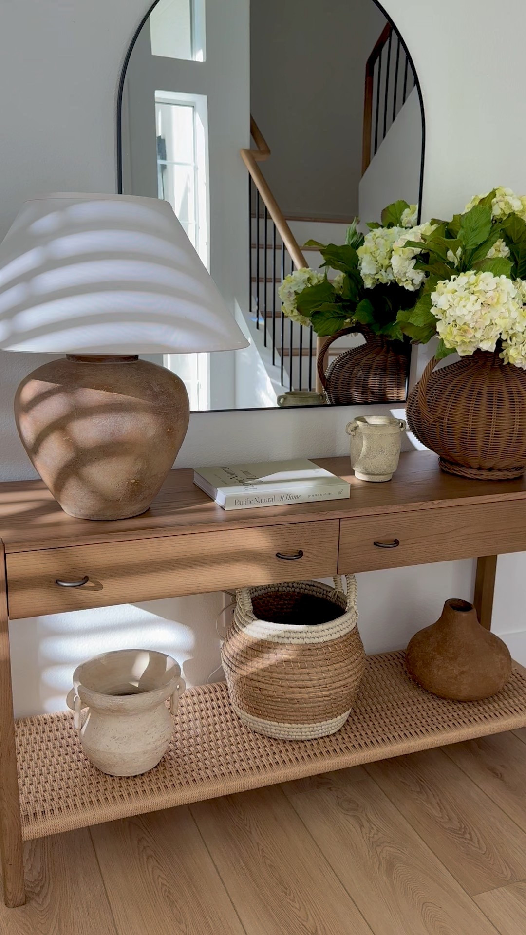 Neutral, earthy and warm console decor. 

Warm wood tones, console table, earthy table lamp, woven vase, faux hydrangeas, vases, arched mirror. 

#LTKStyleTip #LTKHome #LTKSeasonal