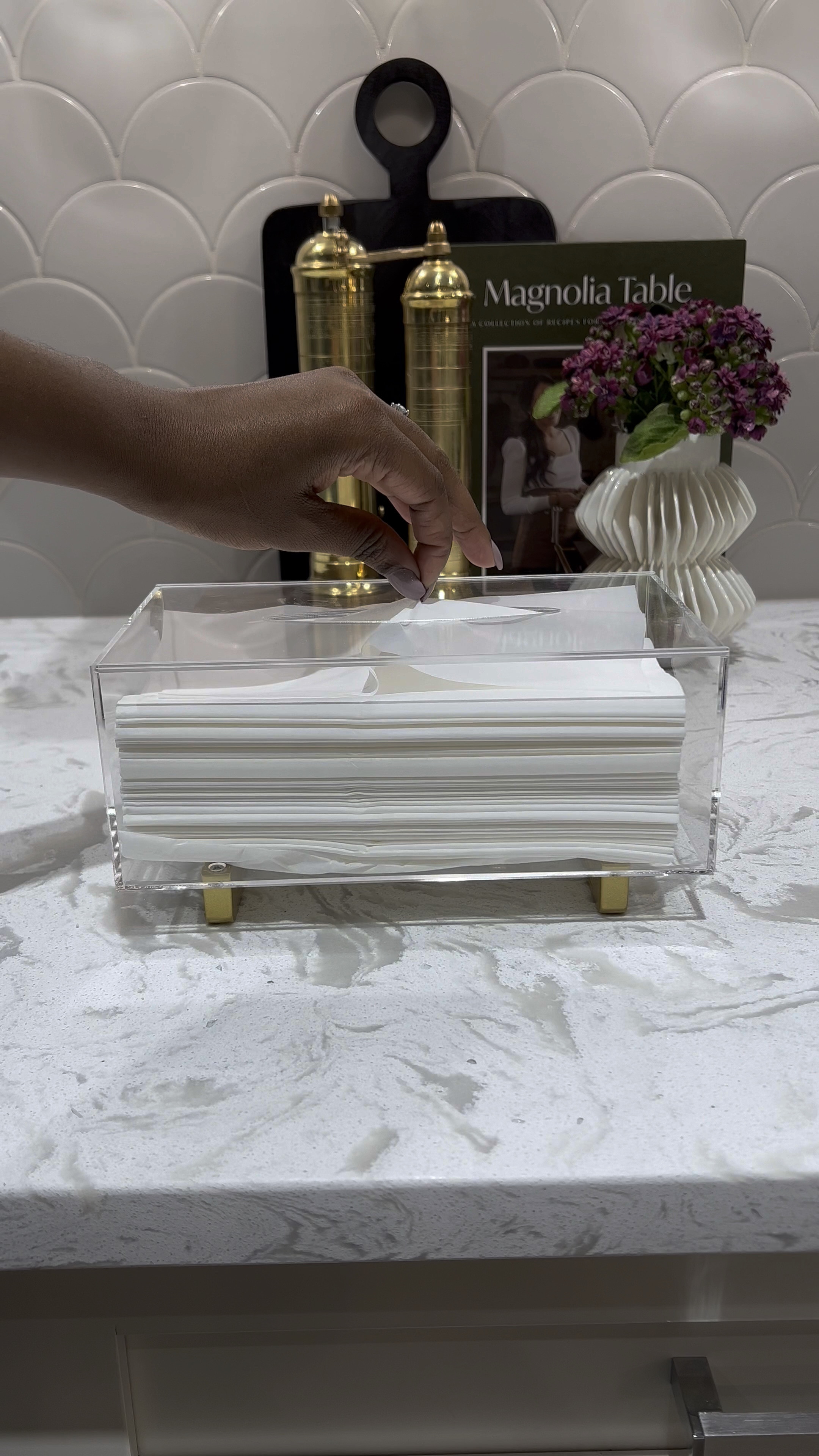 I love this acrylic tissue paper holder. It adds an elegant touch to any space. Style it on your bathroom or on any side table! 💕

Kleenex holder 
Tissue holder 
Salt and pepper mill 
Wooden pedestal tray
Small white vase
Countertop styling 
