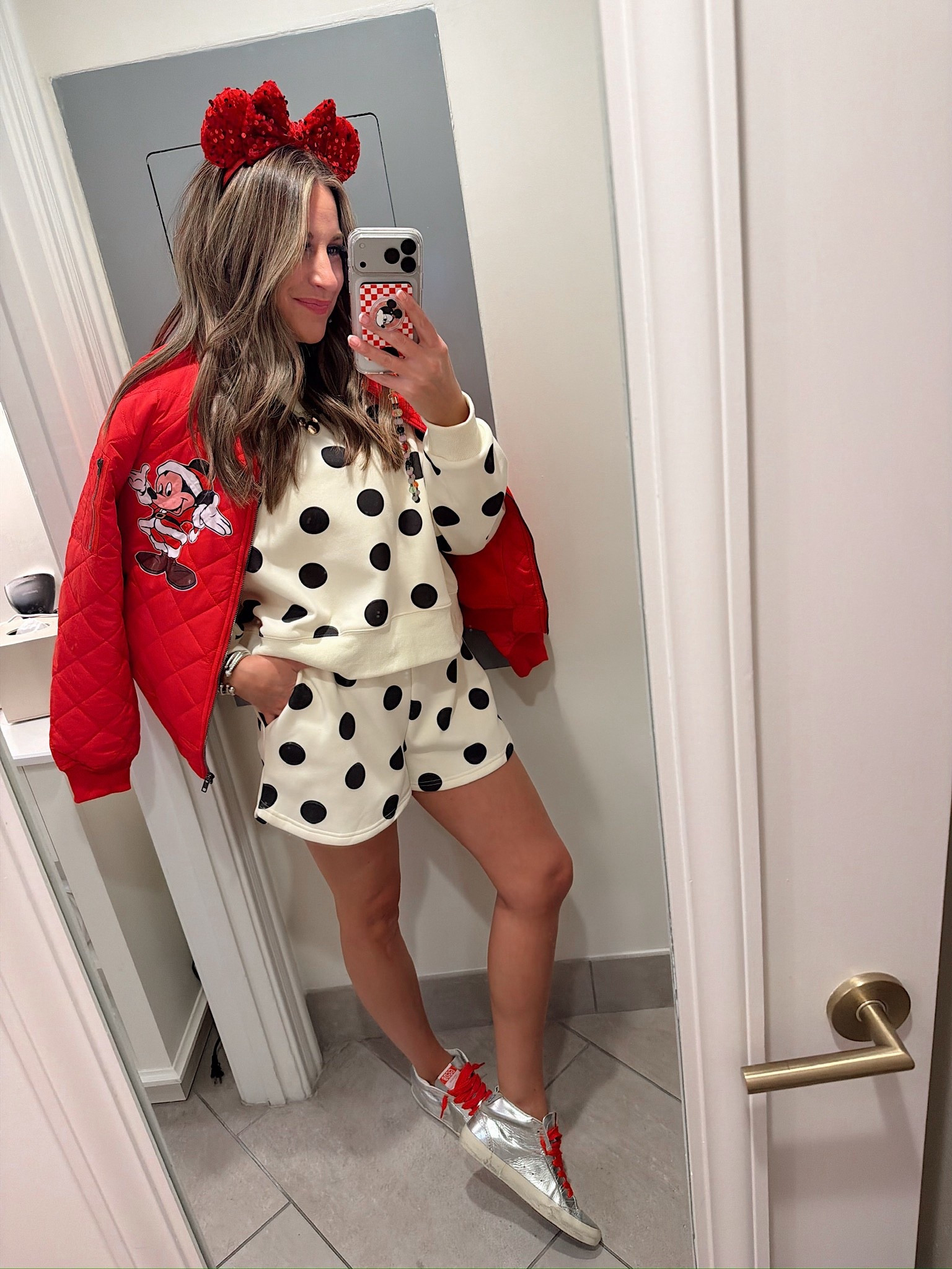 In a medium polka dot sweatshirt and shorts, medium jacket with iron on patch, sequin Minnie Mouse ears and accessories - what to wear at Walt Disney World at Christmas! 

#LTKTravel #LTKHoliday #LTKootd