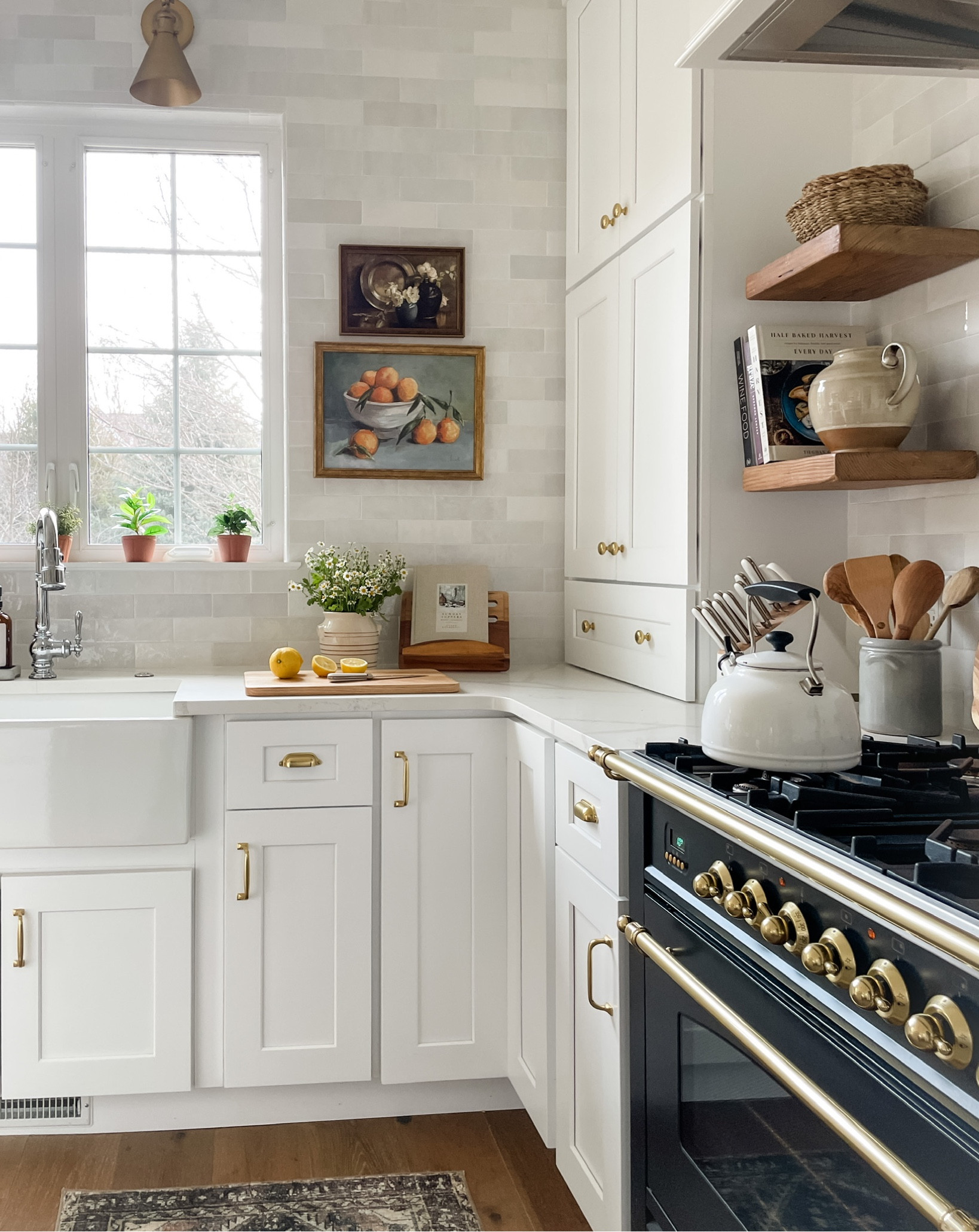 Kitchen styling: white backsplash, farmhouse sink, pull down faucet, wood floating shelves, white cabinets, gold hardware, spring florals, framed art, cookbook holder,

#LTKstyletip #LTKhome #LTKSeasonal