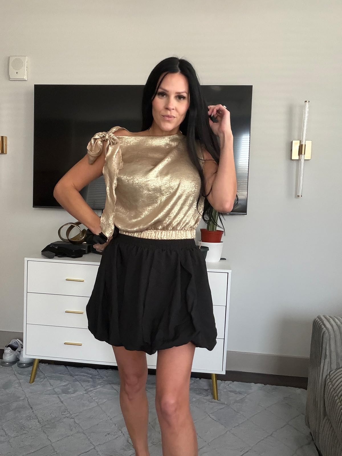 Golden hour glamour. This shimmering metallic gold shoulder-tie blouse paired with a chic black bubble skirt is the perfect high-low silhouette for a night out. #NightOutLook #GoldTop #LTKstyletip 

 #LTKdayinmylife #LTKgrwm #LTKootd