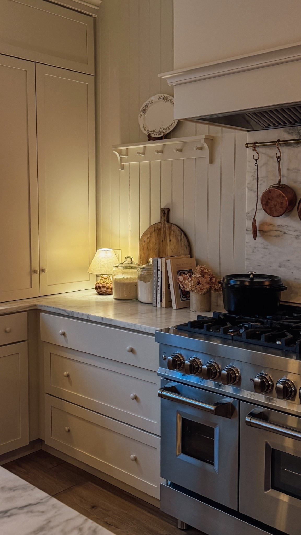 Timeless English cottage-inspired kitchen with warm lighting, creamy cabinetry, and vintage accents. Featuring a cozy countertop kitchen lamp, marble countertops, and a classic gas range #EnglishCottage #KitchenDesign #TimelessInteriors 

#LTKHome