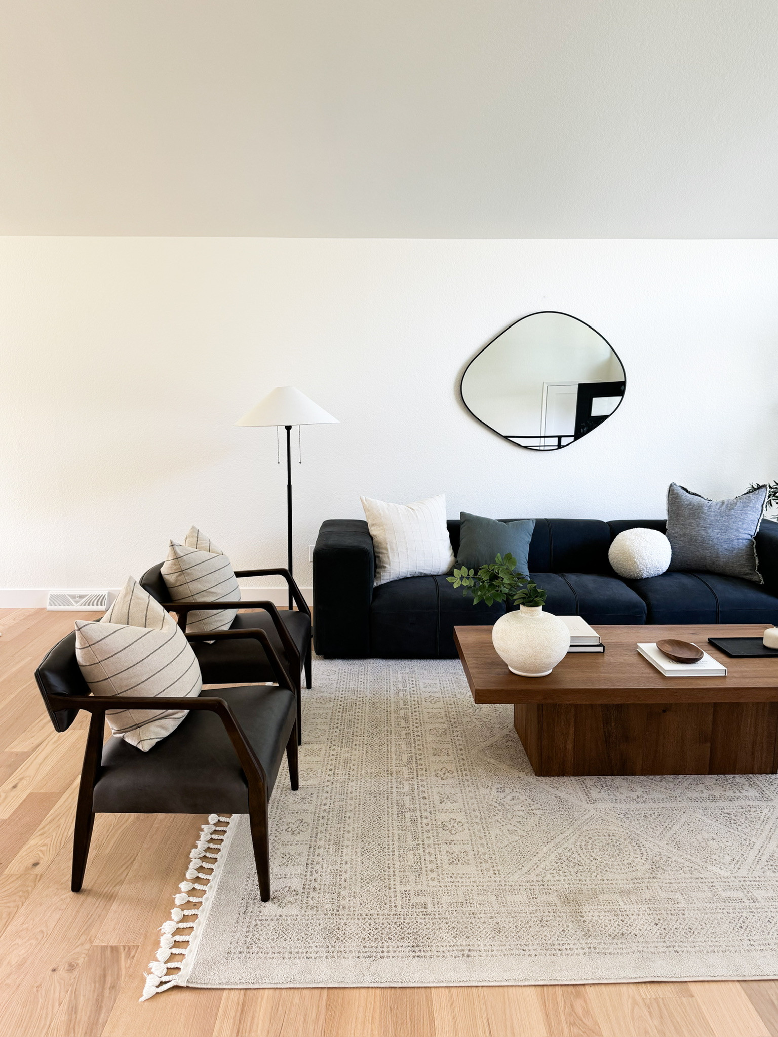 Blue sofa couch, black leather chairs, wooden coffee table, accessories, throw pillows, oblong mirror 

 #LTKHome #LTKFindsUnder100 #LTKStyleTip