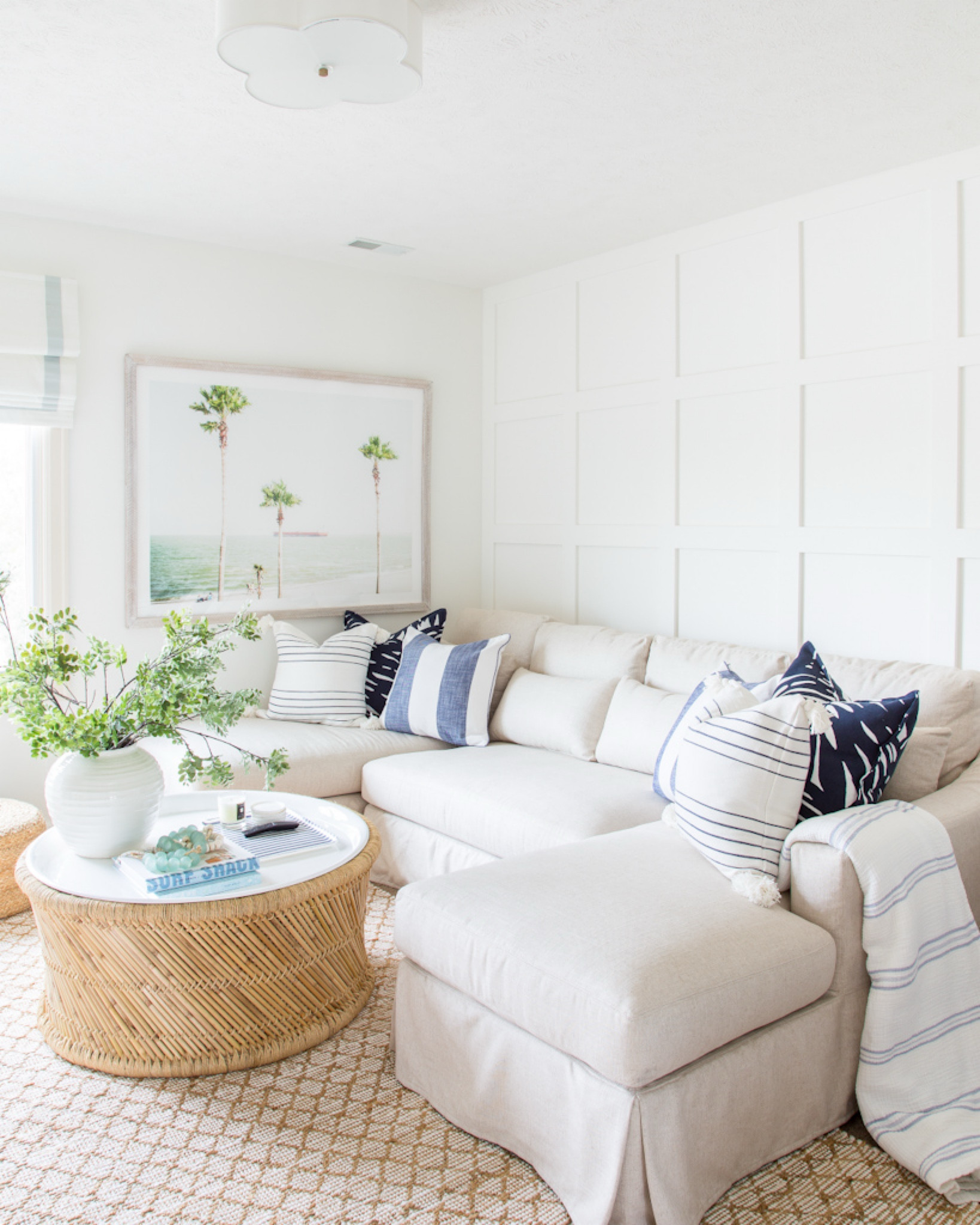 Our coastal den decorated for spring and summer! Our slipcovered linen sectional is paired with these blue and white throw pillows, a round rattan coffee table, palm tree art, diamond jute rug, round jute poufs, scalloped light fixture and fabric Roman shades!
.
#ltkhome #ltksalealert #ltkfindsunder100 #ltkstyletip #ltkseasonal #ltkfindsunder50 coastal decorating ideas, cozy TV rooms, living room decor, family room furniture

#LTKSaleAlert #LTKHome #LTKSeasonal