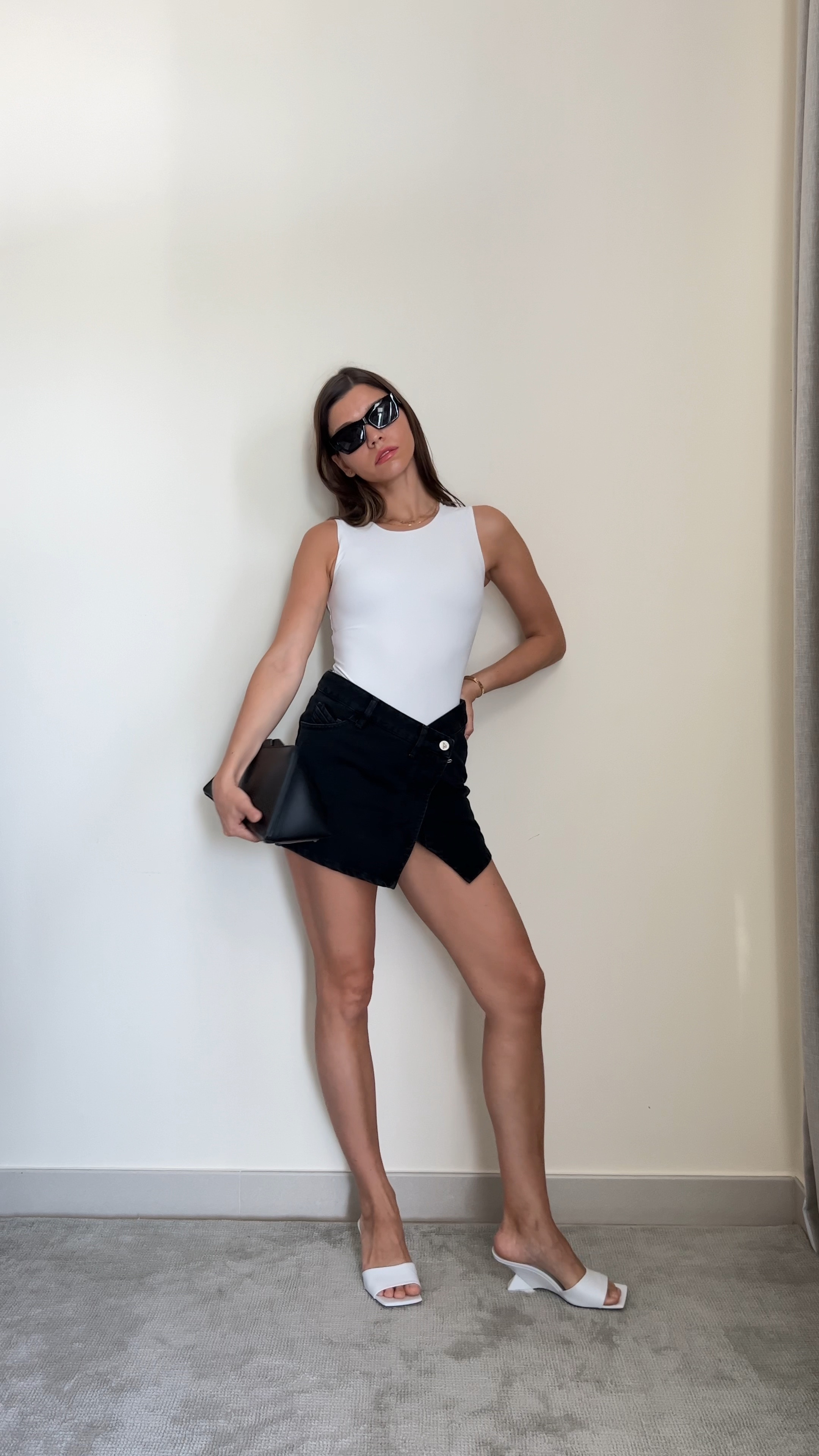 Summer outfit idea: White bodysuit, black wrapped skirt, black leather clutch, black sunnies, white leather mules

#LTKshoecrush #LTKFind #LTKSeasonal