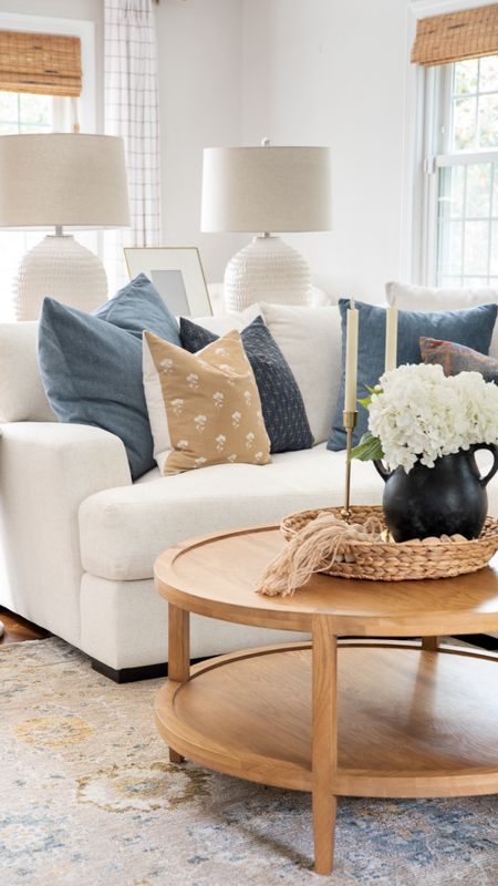 Coastal style living room with white couch, roundwood coffee table, decorative, throw pillows, large lamps, artificial flowers, ceramic vase, and more home accessories

#LTKhome #LTKfamily