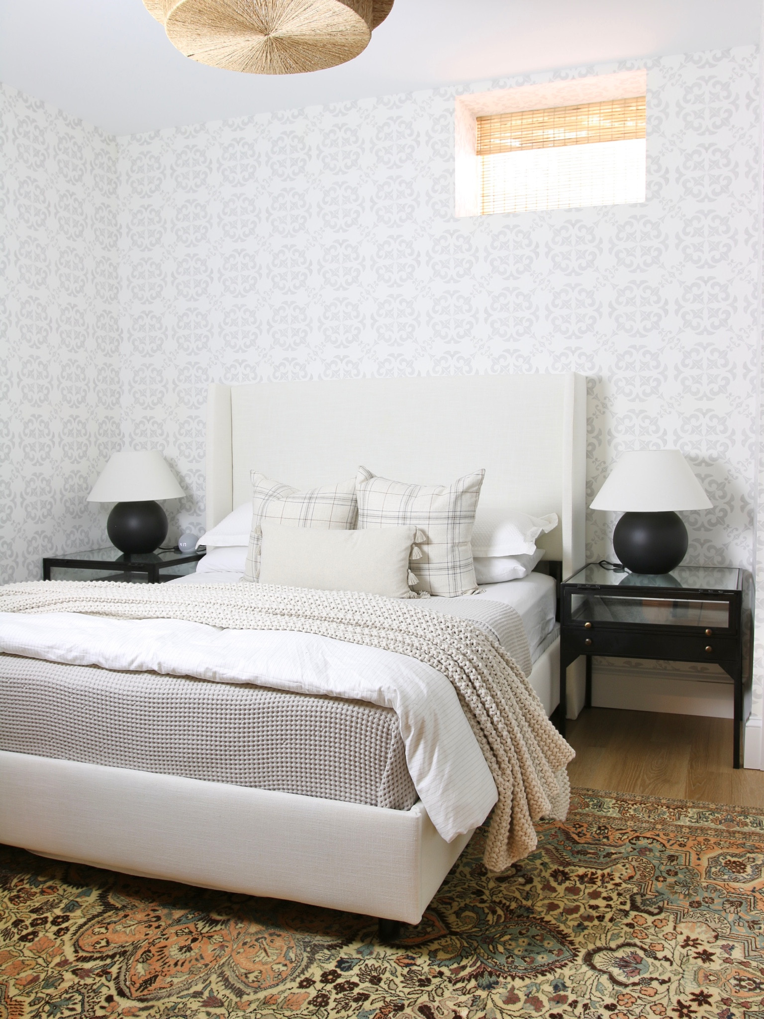 When my younger son moved out of the room he shared with his brother we decided to give him the guest room and replace my basement office with a bedroom. This is the original view. It includes:
A low profile upholstered bed, ceramic table lamps, black iron and glasses nightstands, linen sheets and a chunky knit throw blanket 

#LTKhome #LTKstyletip #LTKFind