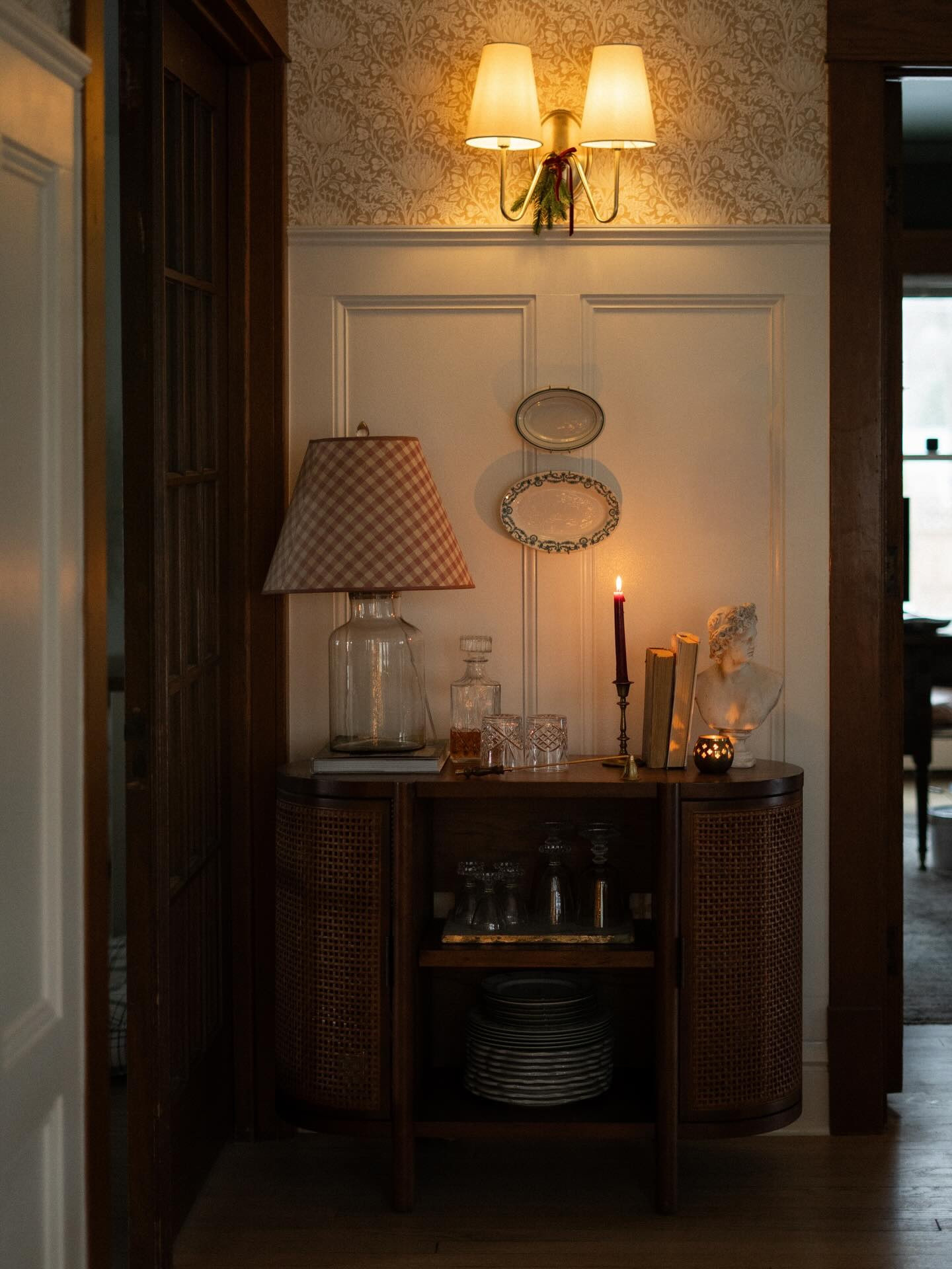 It’s been a while since I’ve shared one of my favorite corners of our dining room. 🥰 She’s especially perfect this time of year 🎄

Room Details:
•Wallpaper: from @northandfinch - Aspen Floral
•Paint: White Dove by @benjaminmoore 
•Cabinet: @target (but often not in stock)
•Sconce light: @rejuvenation 
•Lamp shade: thrifted 

-

#kindredhomestead
#heritageholidayhome
#1920shome
#livedinlovely
#collectedchristmas
#nostalgicchristmasdecor
#heirloomholiday
#vintagechristmashome
#patternlayeredliving
#homefortheseason