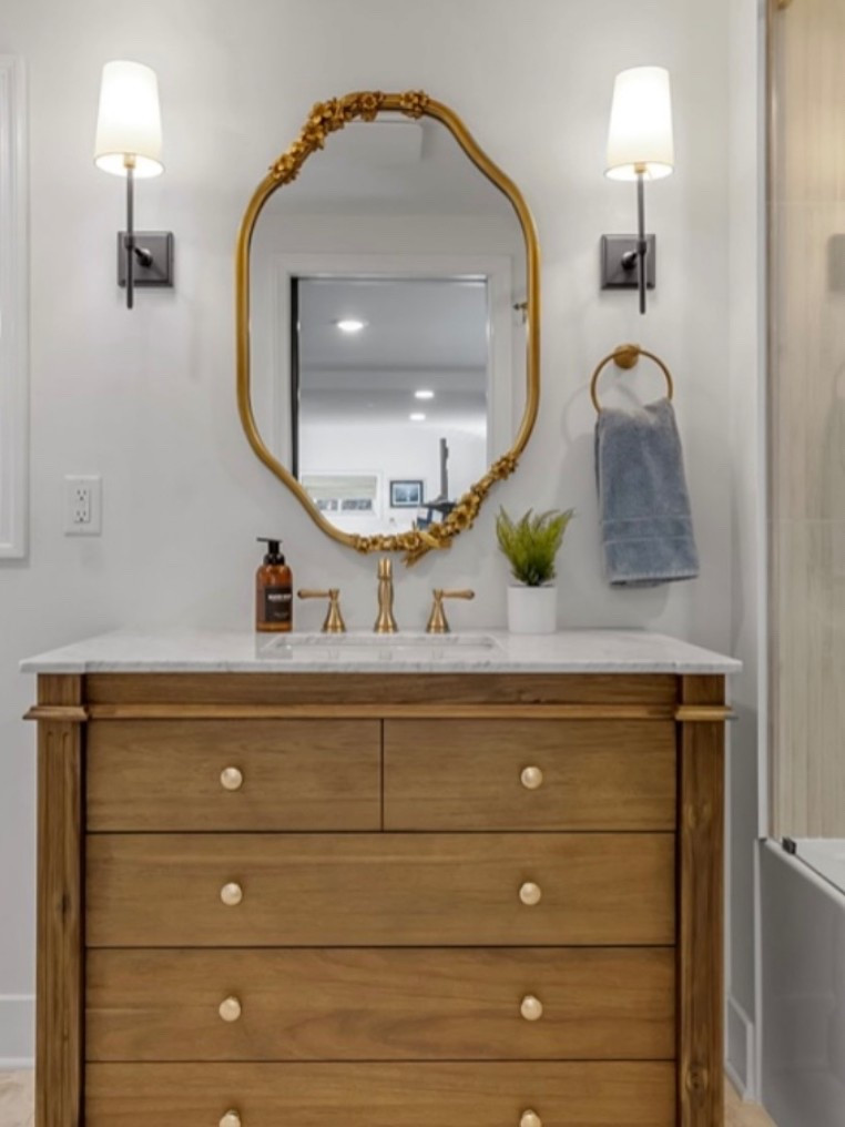 This luxury Airbnb bathroom blends warmth and sophistication through layered textures and timeless finishes. The natural wood vanity and gold mirror create a calming focal point, while soft lighting and neutral tones make it feel like a boutique hotel at home.

#airbnbdesign #luxurybathroom #interiordesign #ltkhome #neutraldecor #bathroominspo #cozyandcurated #designgoals

#LTKHome #LTKStyleTip