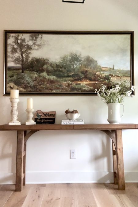 My foyer home decor

Console table
Landscape canvas framed print
Candleholder
Table books
Pitcher vase
Flower stems