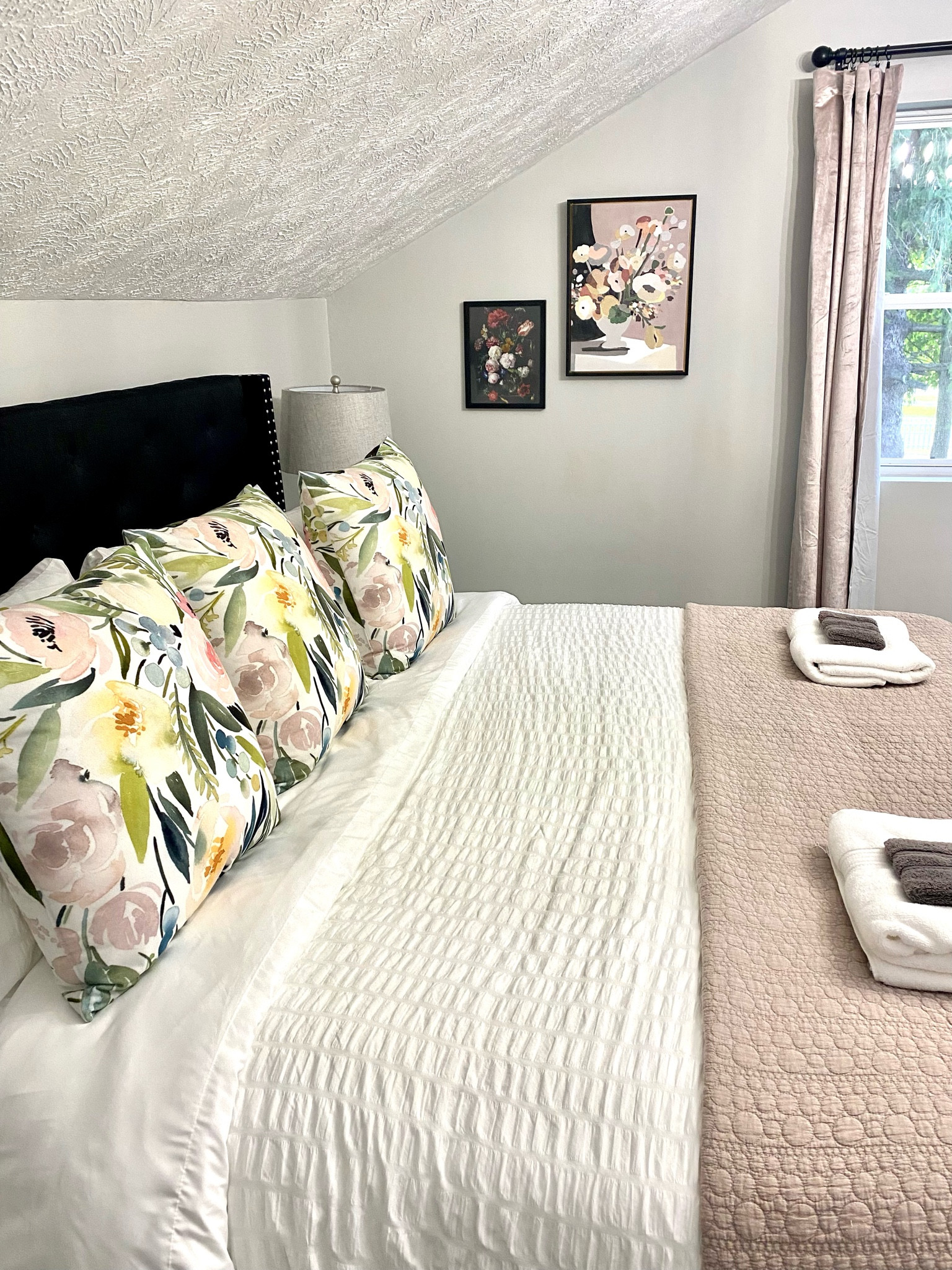 King guest bedroom modern farmhouse decor for your home or vacation rental property. Black tufted headboard, white duvet and sheets, with floral accent pillows.

#LTKstyletip #LTKtravel #LTKhome