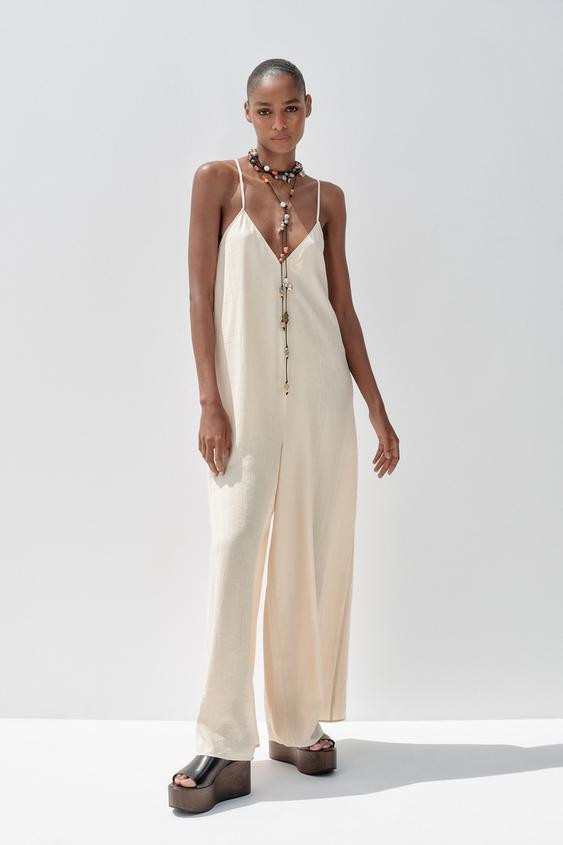 Long jumpsuit made in flowy fabric. V-neckline and thin adjustable straps that cross in the back.... | Zara US